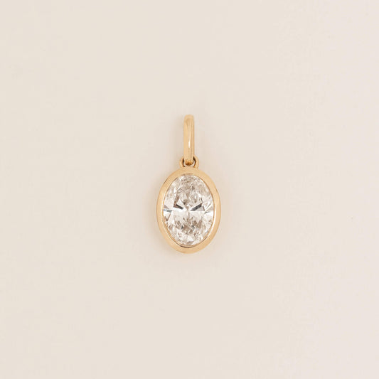 Yellow Gold oval shaped pendant with a polished finish, shown against a light neutral background.