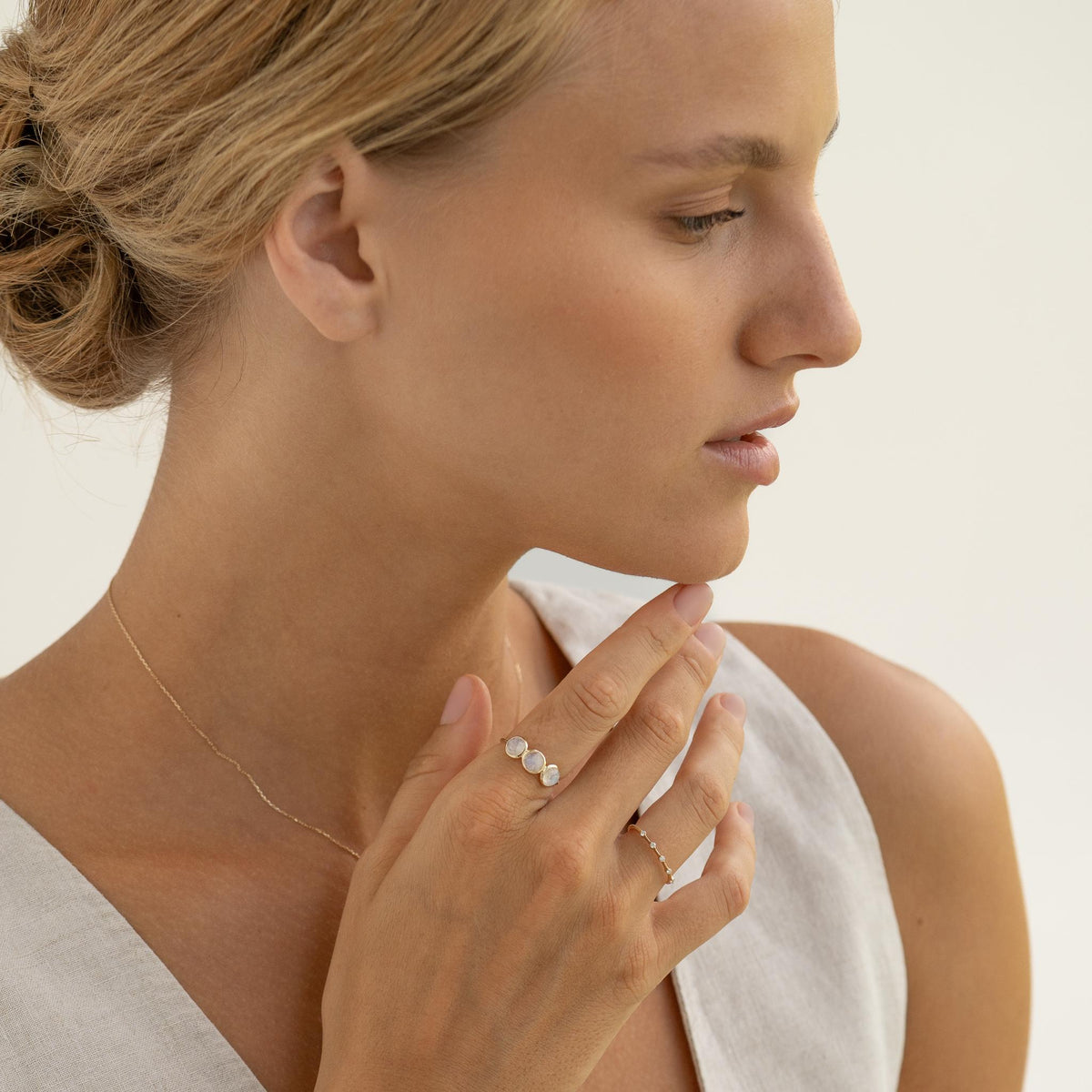 Close-up of a woman wearing the Moonstone Ring 14k Gold - Elisa with three moonstones on a gold band