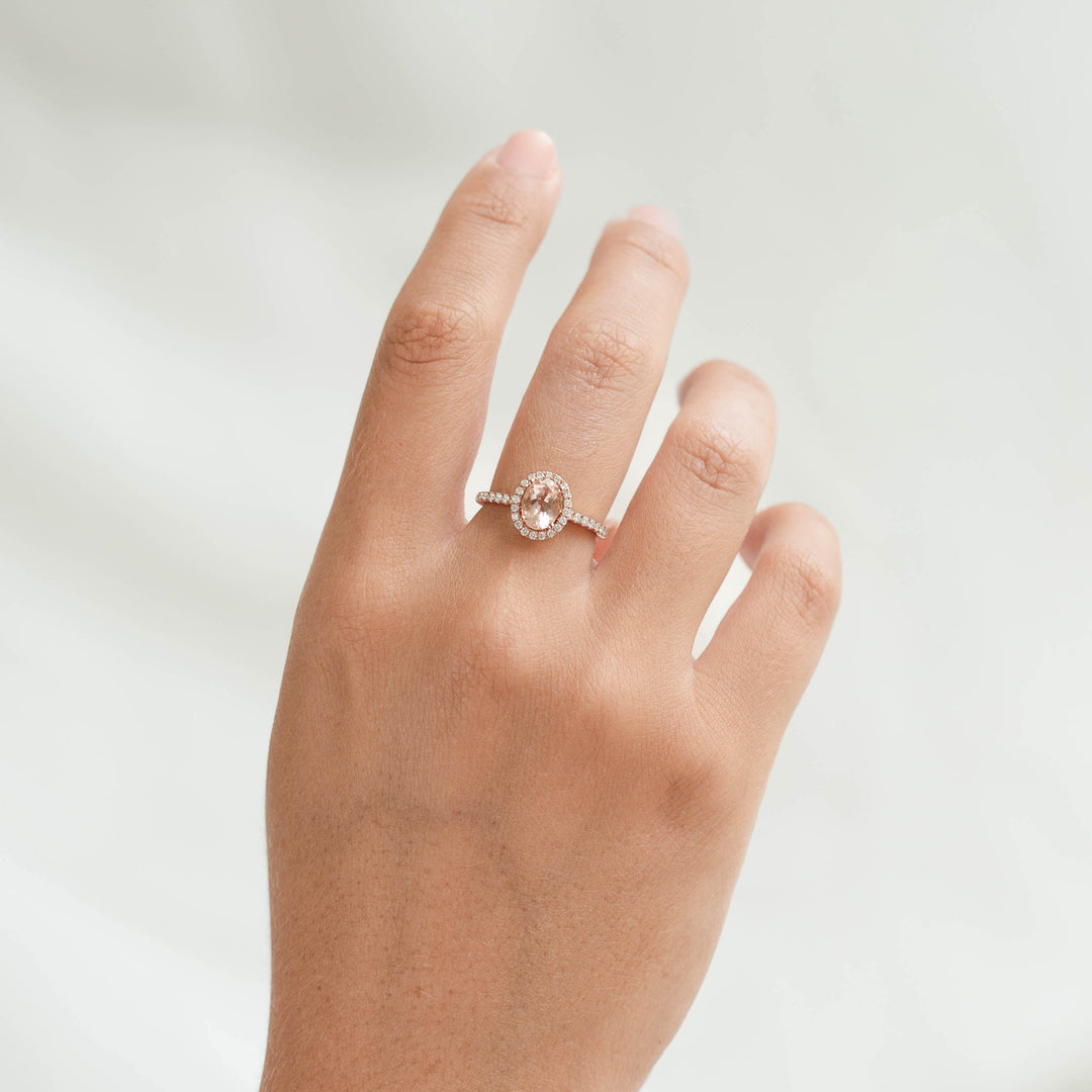 Oval Morganite Halo Ring Rose Gold - Suna worn on hand with pavé diamonds and soft neutral background