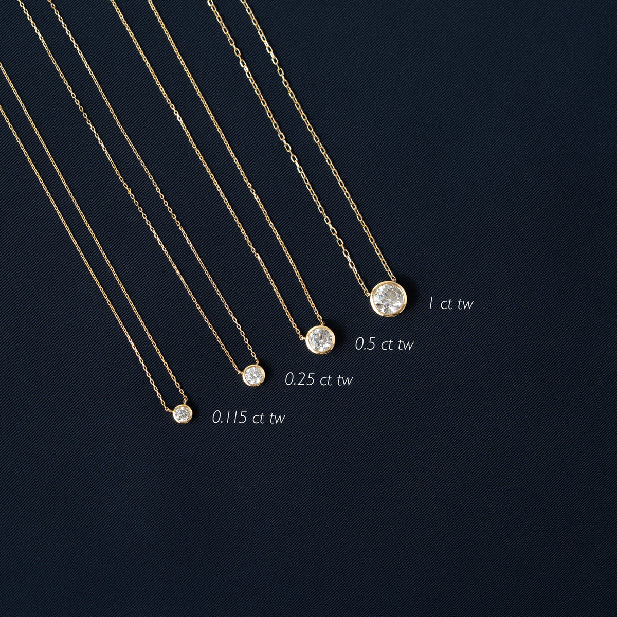 Four gold chain necklaces with round clear diamond pendants in different carat weights, arranged diagonally on a dark navy background with size labels.