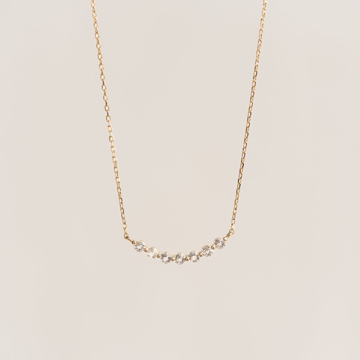 Close-up of April Birthstone Necklace 14k Gold - Diamond featuring a curved diamond bar on a delicate gold chain