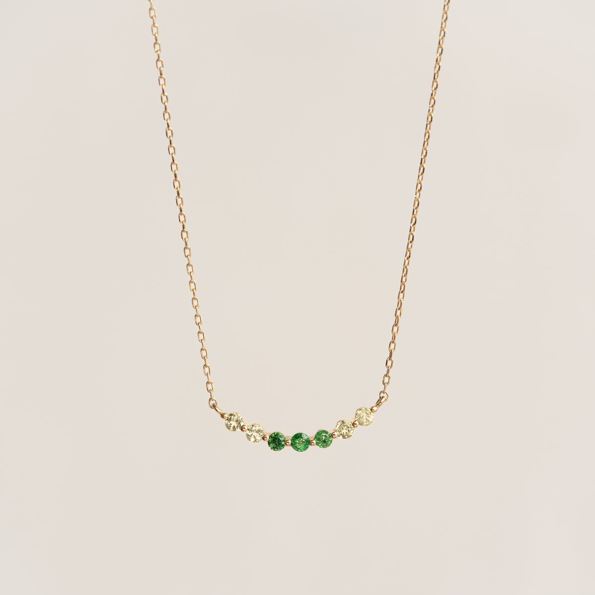 Close-up of August Birthstone Necklace 14k Gold - Ombre Tsavorite with green and light yellow gemstones on gold chain