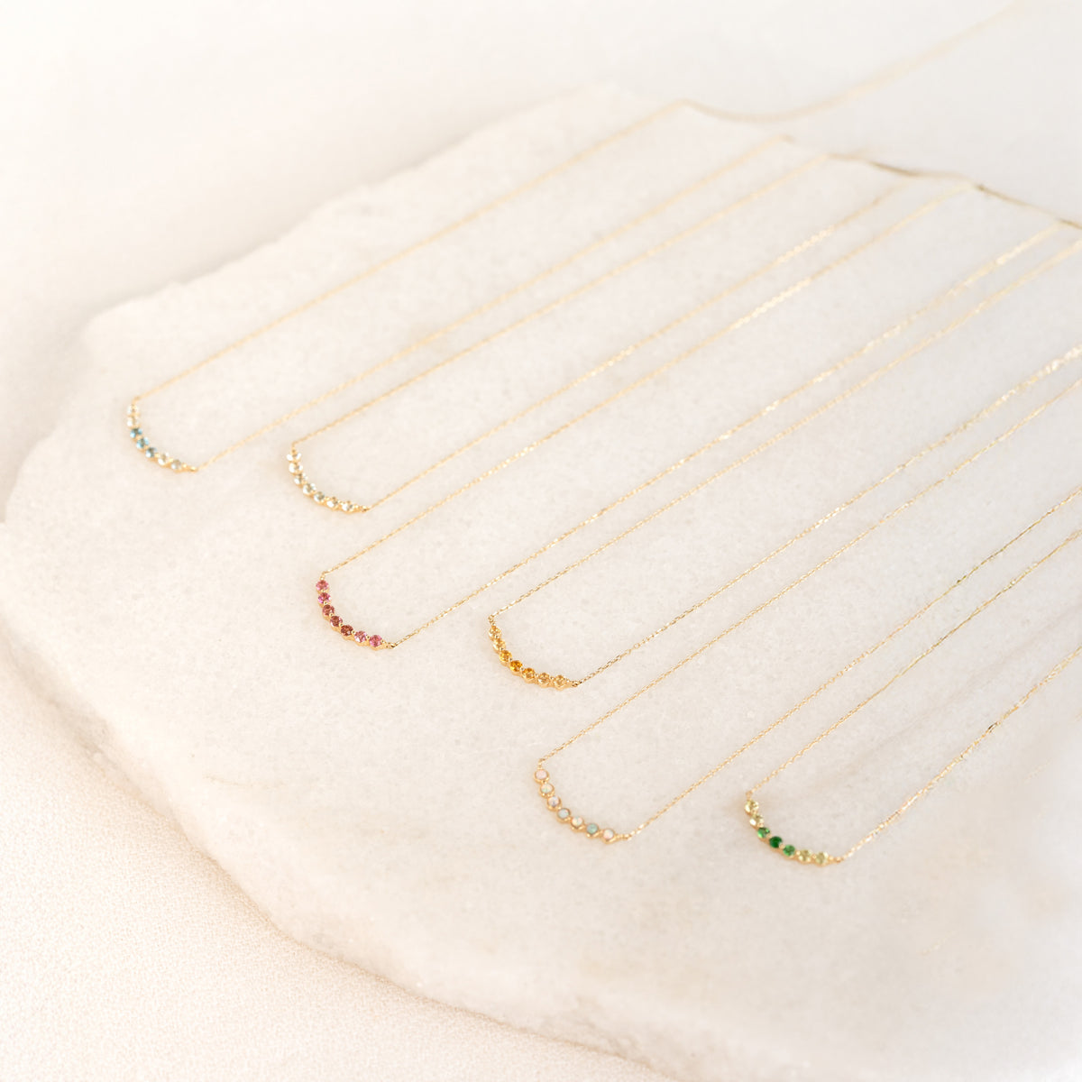 Six August Birthstone Necklace 14k Gold - Ombre Tsavorite with delicate gemstone curves on a soft white surface