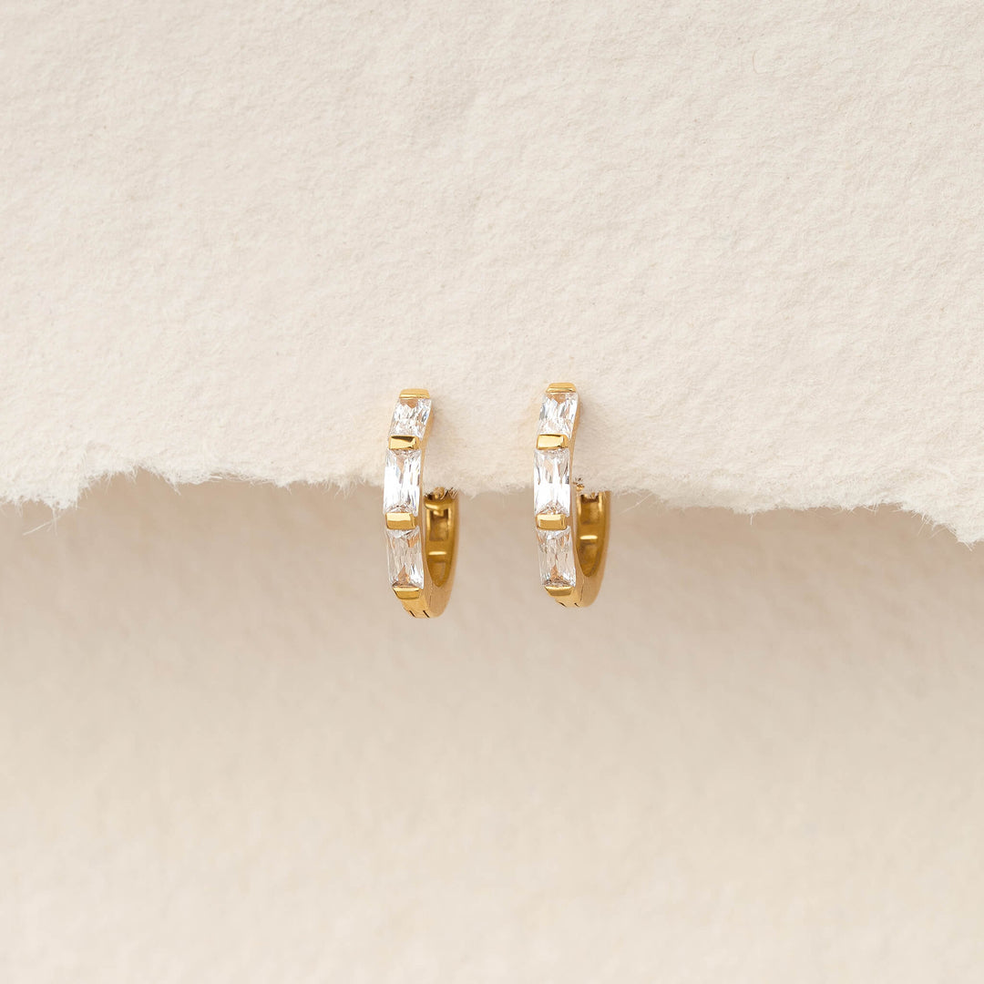 Pair of Gold Vermeil earrings set with baguette-cut gemstone, displayed hanging against a soft, textured ivory background.