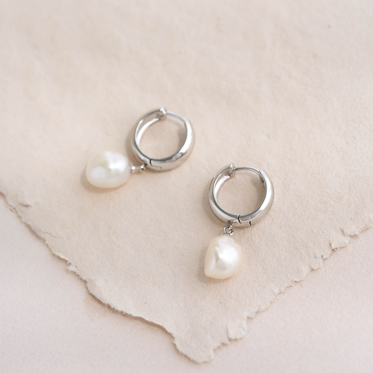 Close-up of Baroque Pearl Chunky Hoop Earrings Silver - Meredith featuring sterling silver hoops with freshwater pearls on neutral background