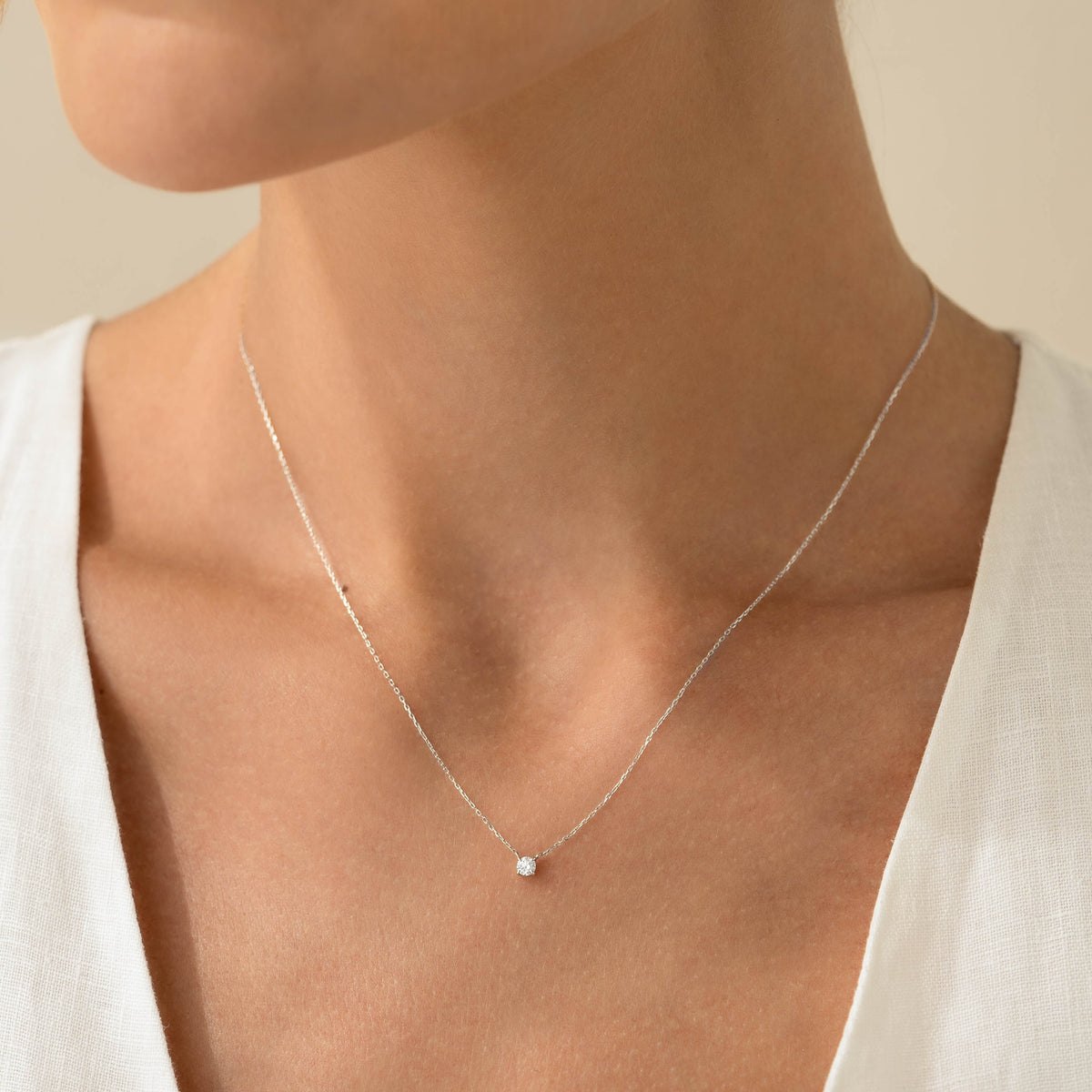 Close-up of a woman wearing Diamond Pendant Necklace White Gold - Johanne with a delicate white gold chain and diamond pendant