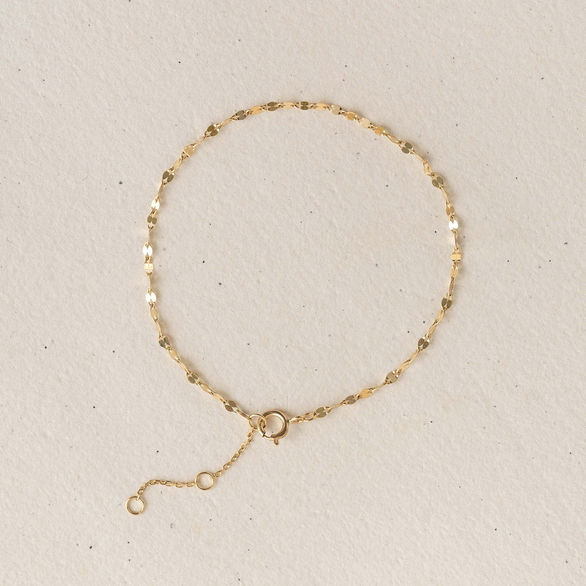 Petal Chain Bracelet 14k Gold - Florence with delicate petal-shaped links on a light beige background