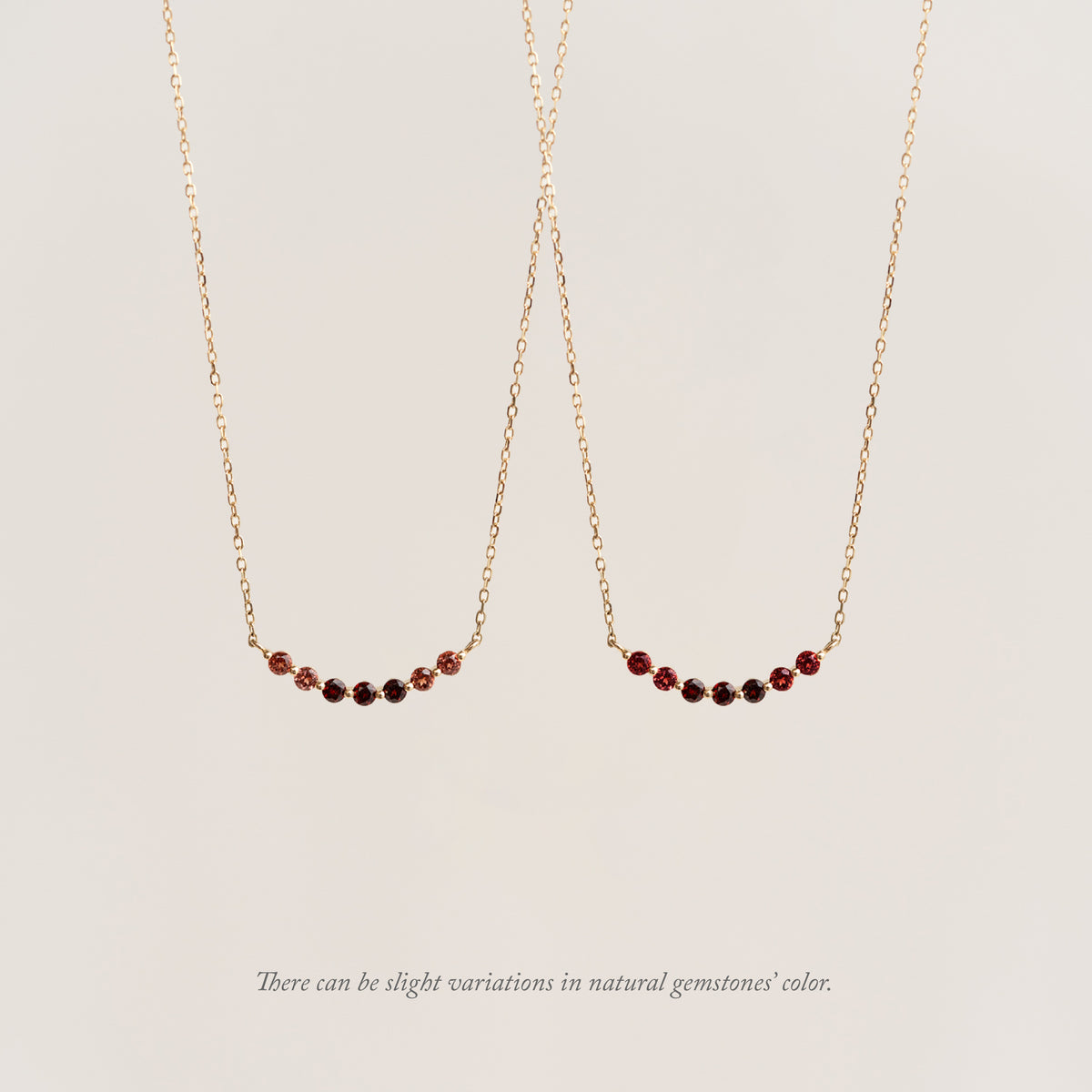 January Birthstone Necklace 14k Gold - Ombre Garnet on a beige background with a note that there can be slight variations in natural gemstones' color