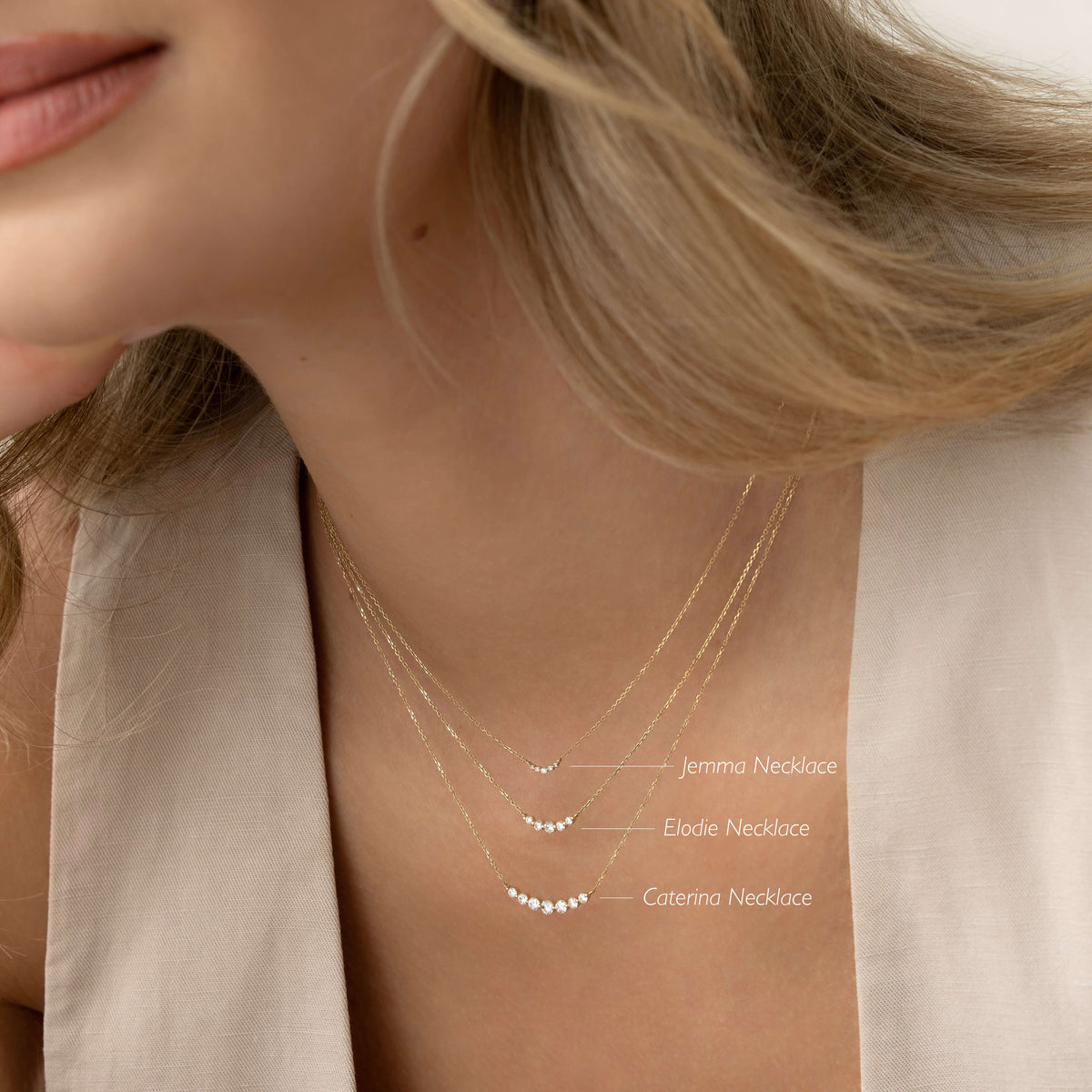 Close-up of woman wearing layered Diamond Curved Bar Necklace 14k Gold - Jemma with a neutral beige top