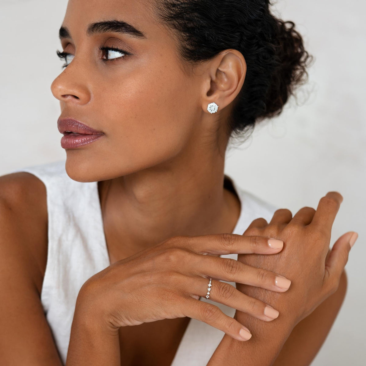 Close-up of a woman wearing Diamond Earrings - 3 Carat Miracle Plate styled with a white sleeveless top