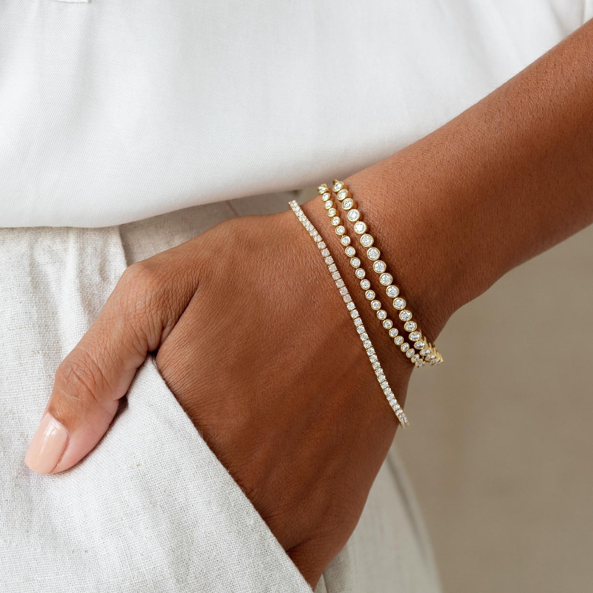 Half Diamond Tennis Bracelet 14k Yellow Gold (1.8 - 2.0 ct tw) worn on wrist with white linen outfit background