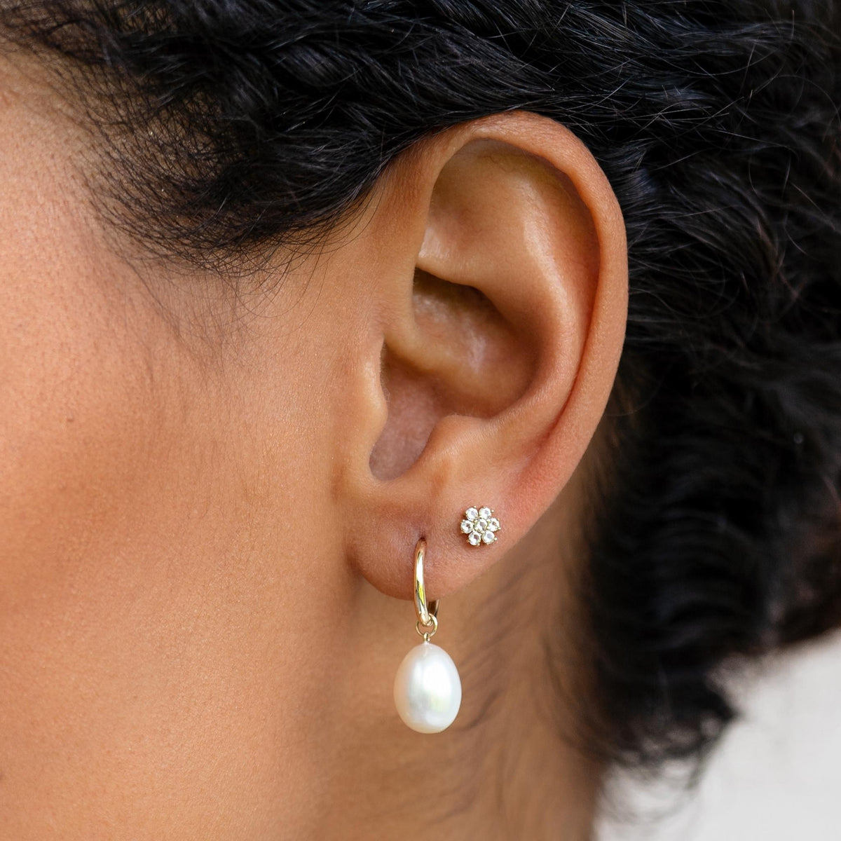 14k solid gold rice pearl huggie earring stacked with 14k gold flower stud