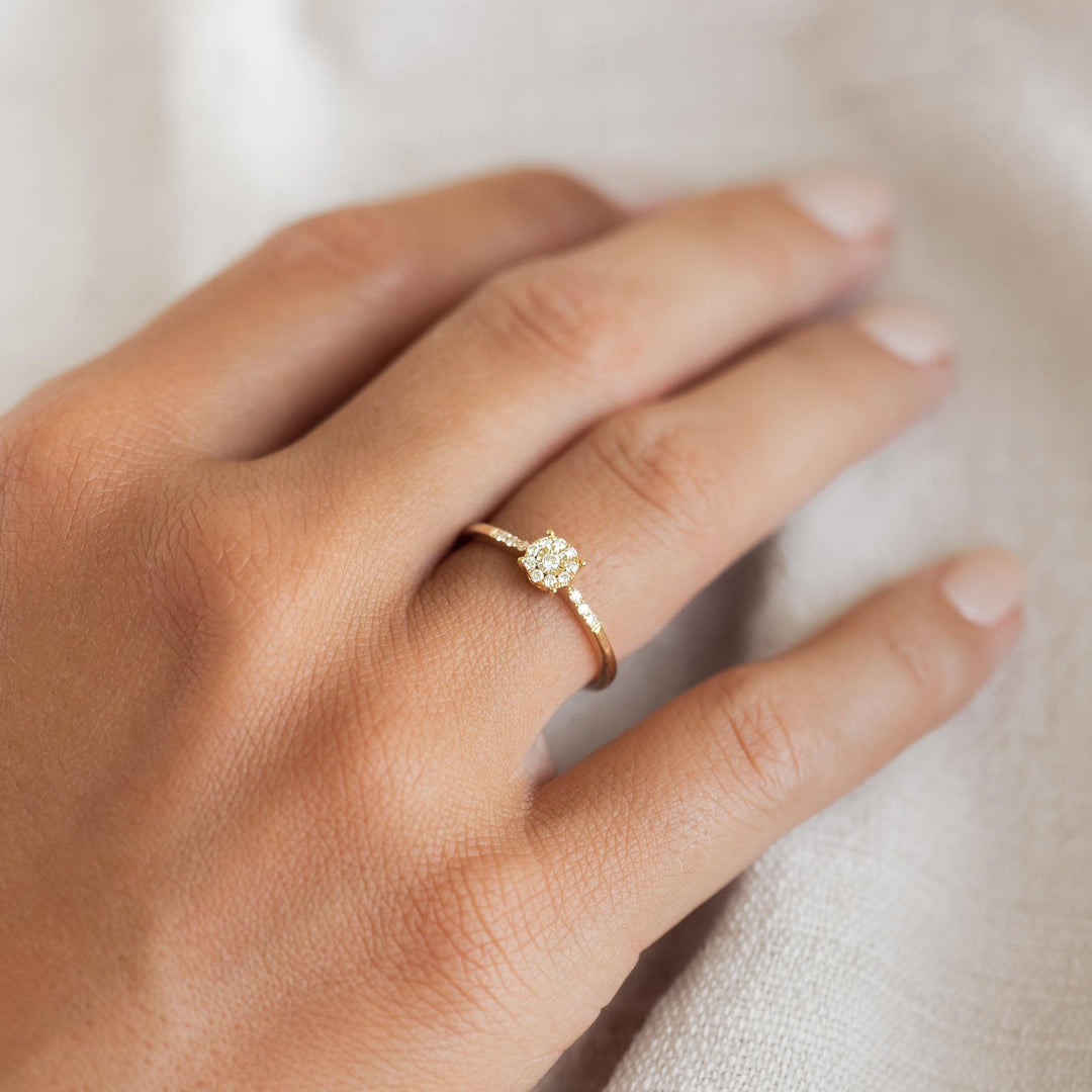 Close-up of hand wearing Round Cluster Diamond Ring 14k Gold - Zaira with sparkling diamonds on 14k yellow gold band