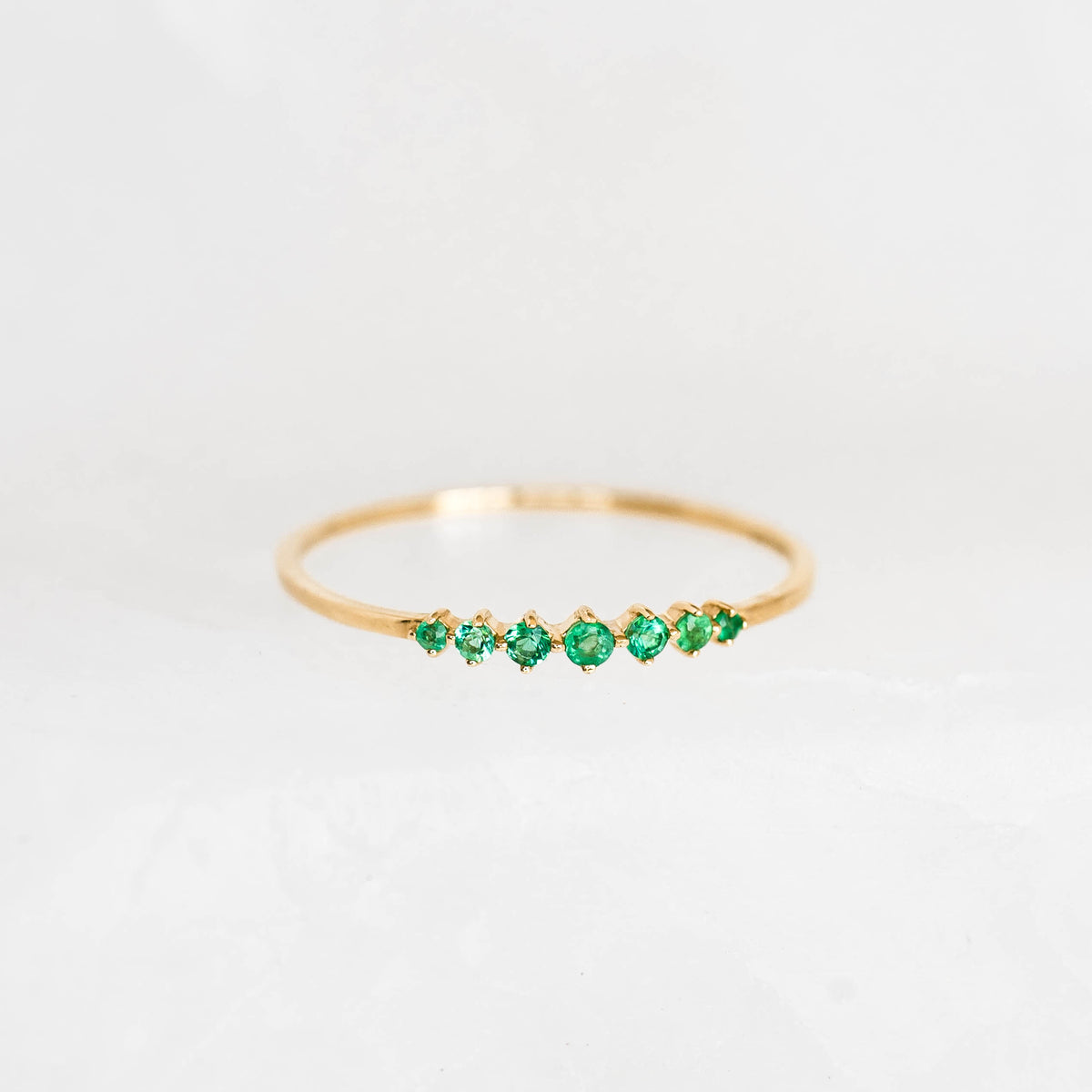 Graduated Emerald Ring 14k Gold - Mila with seven round emeralds in varying sizes on a delicate gold band