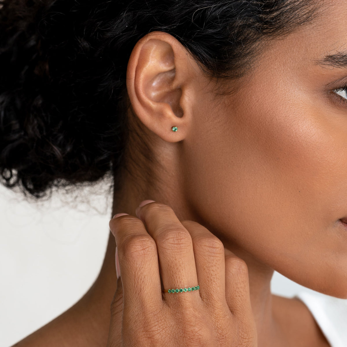 Close-up of a woman wearing the May Birthstone Ring 14k Gold - Green Chalcedony on her finger with matching stud earring