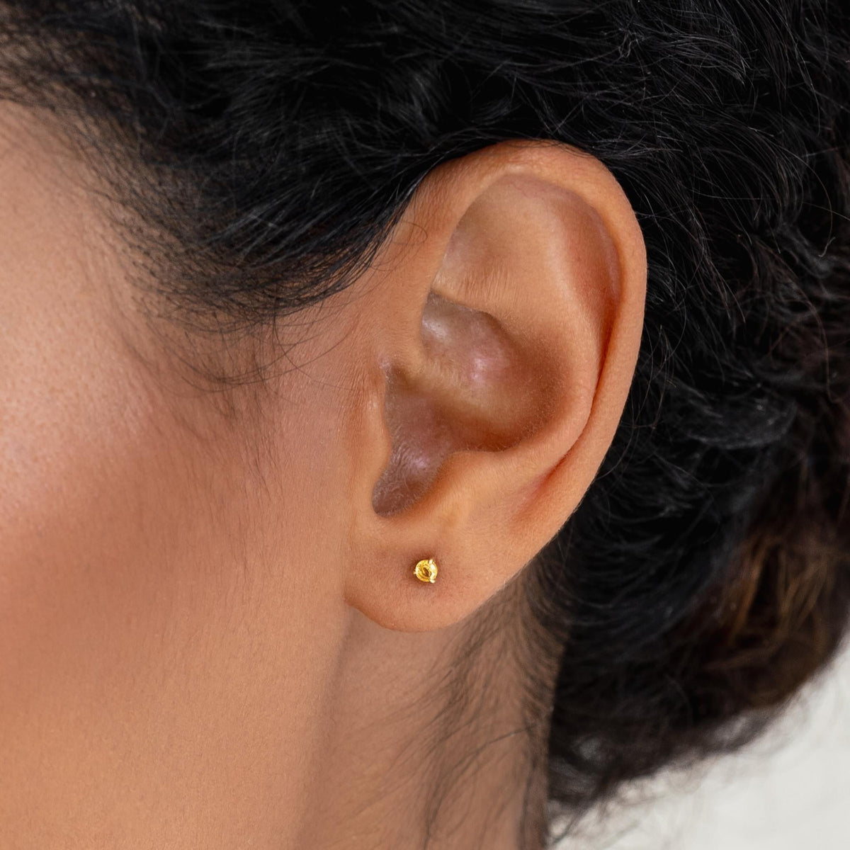 Close-up of a woman wearing November Birthstone Stud Earrings 14k Gold - Citrine on a neutral background
