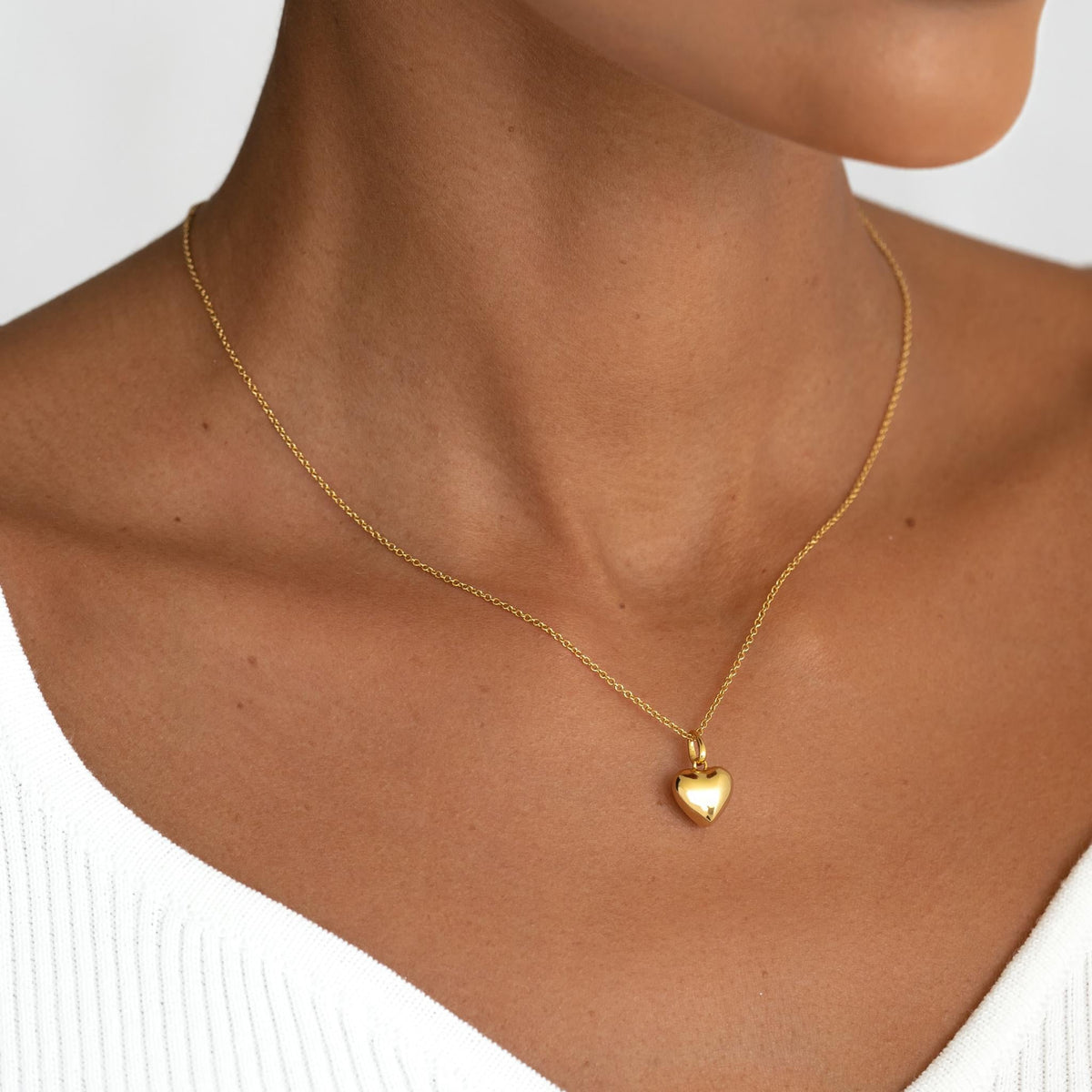 Puffy heart pendant on a delicate chain on model