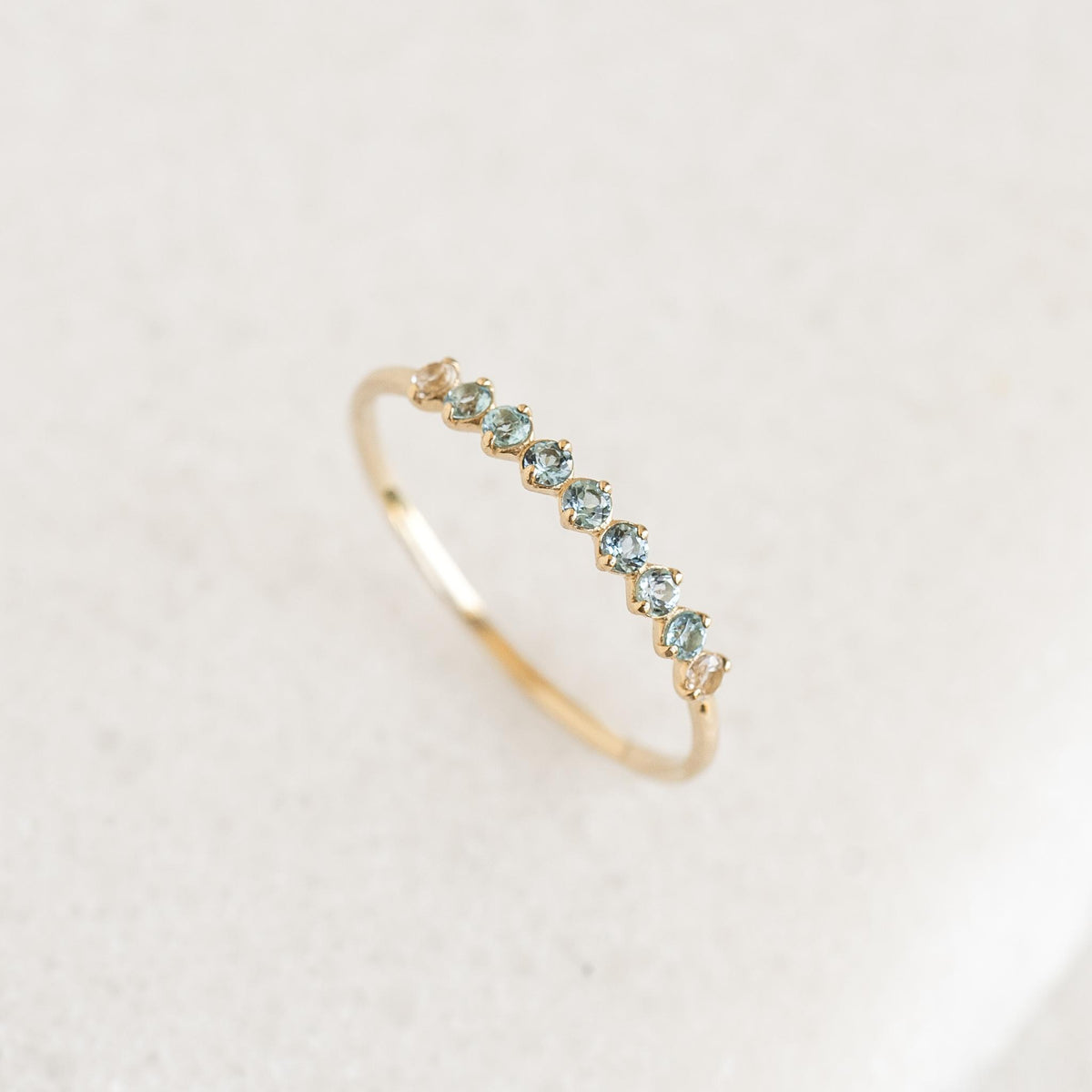 September Birthstone Ring 14k Gold - Ombre London Blue Topaz with delicate ombre blue topaz stones on a light background