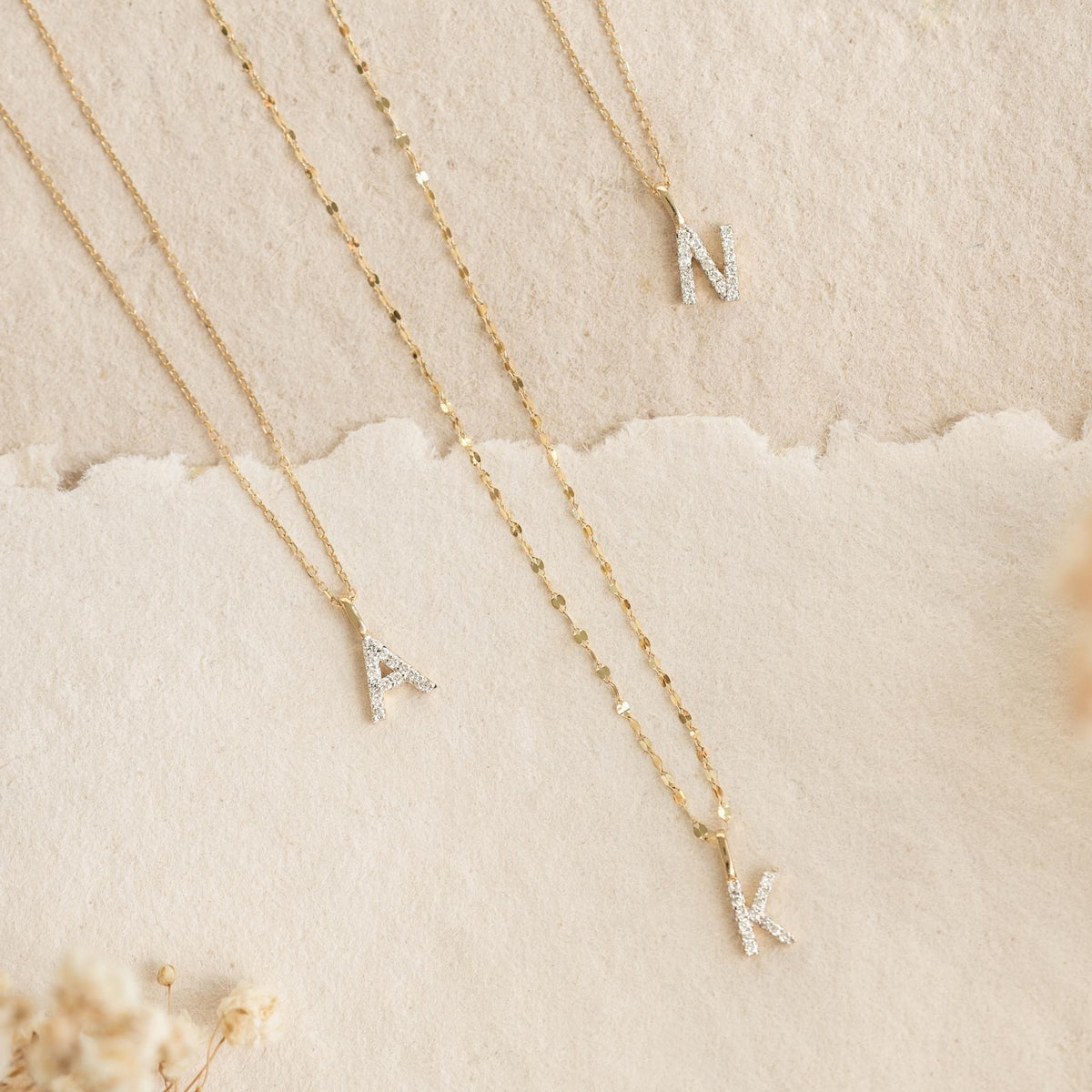 Diamond Initial Pendant 14k Gold - U styled with delicate gold chains and sparkling diamond letter charms on a neutral background