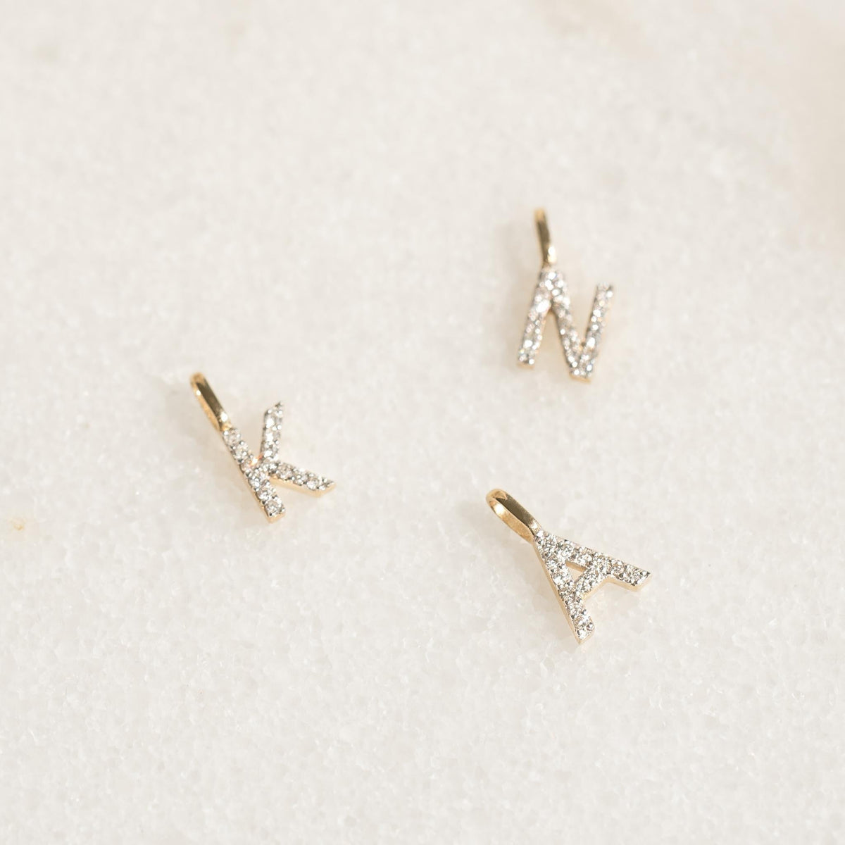 Diamond Initial Pendant 14k Gold - D displayed on a soft white textured background with sparkling diamonds visible