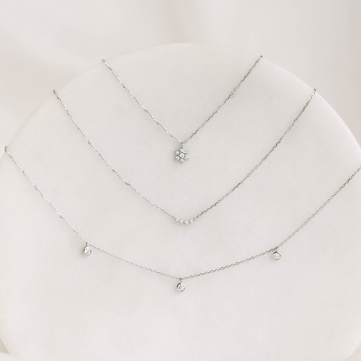 Diamond Flower Necklace White Gold - Haldis with seven diamond petals on a delicate white gold chain displayed on a soft background