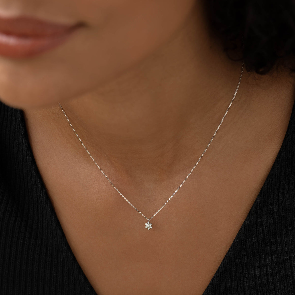 Close-up of a woman wearing Diamond Flower Necklace White Gold - Haldis styled with a black ribbed top