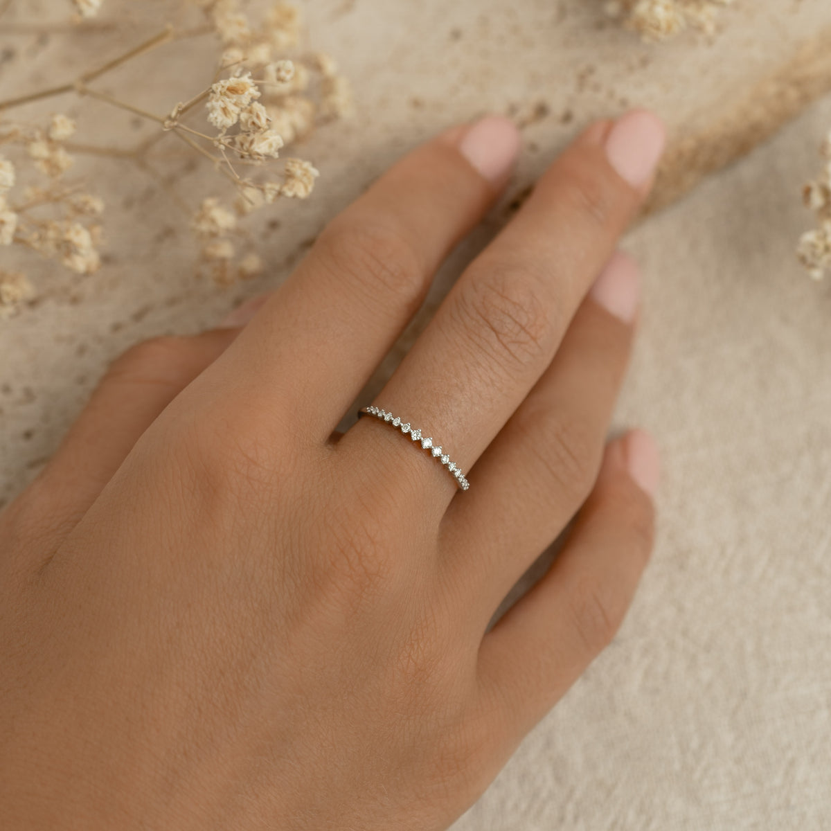 Close-up of hand wearing Graduated Diamond Ring White Gold - Ophelia featuring 15 lab grown diamonds on white gold band