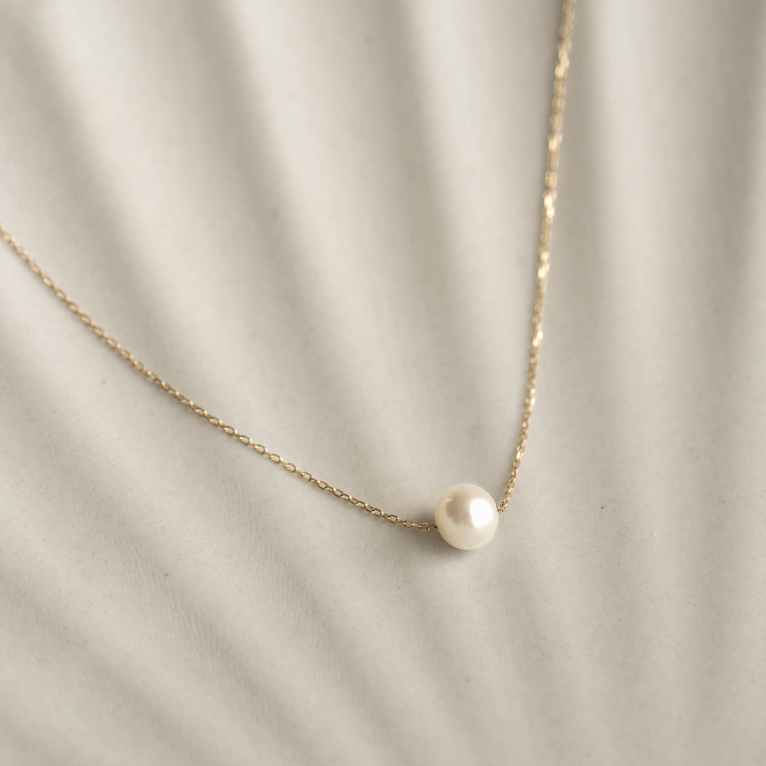 Close-up of Floating Pearl Necklace - Caris featuring a single lustrous pearl on a delicate 14k gold chain