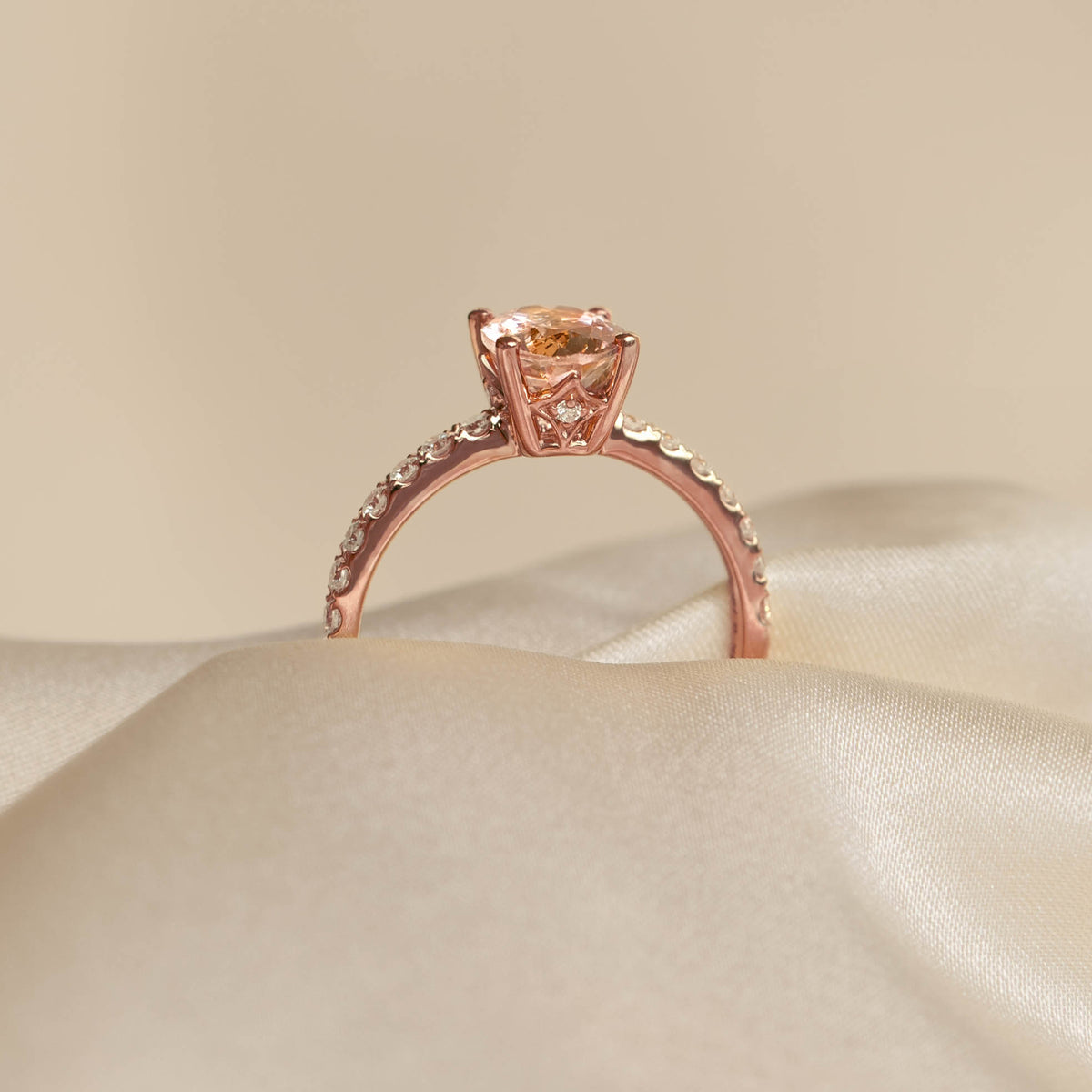 Oval Morganite and Diamond Ring Rose Gold - Minette displayed on soft beige satin fabric with a neutral background
