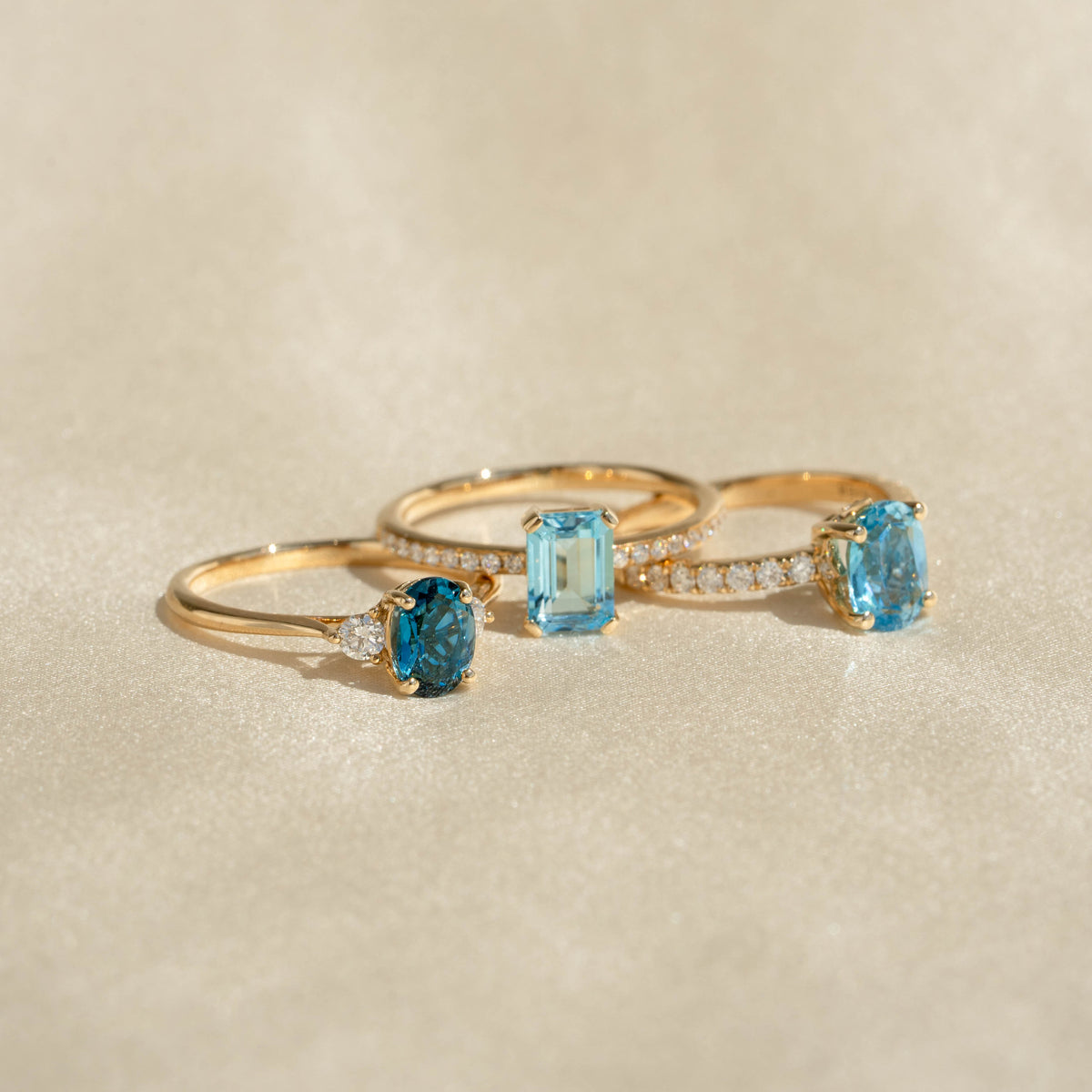 Three gold rings with oval swiss blue topaz and diamond accents, featuring Oval Swiss Blue Topaz and Diamond Ring 14k Gold - Minette