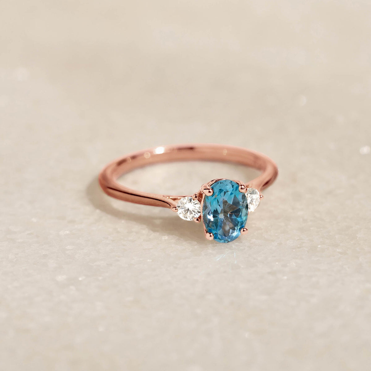 Swiss Blue Topaz and Diamond Ring Rose Gold - Kindra with oval blue topaz and two side diamonds on a rose gold band
