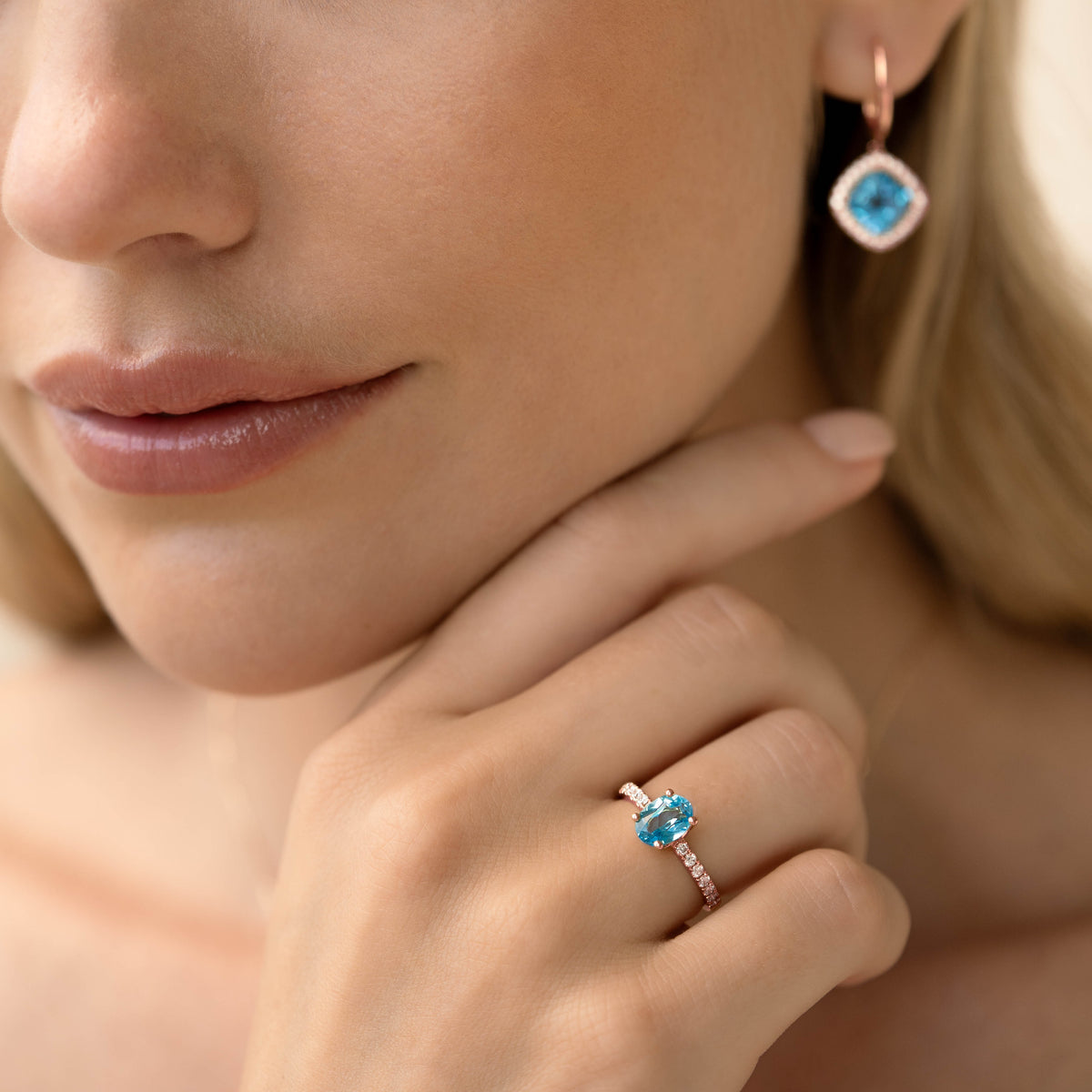 Close-up of woman wearing Oval Swiss Blue Topaz and Diamond Ring Rose Gold - Minette with matching blue topaz earrings