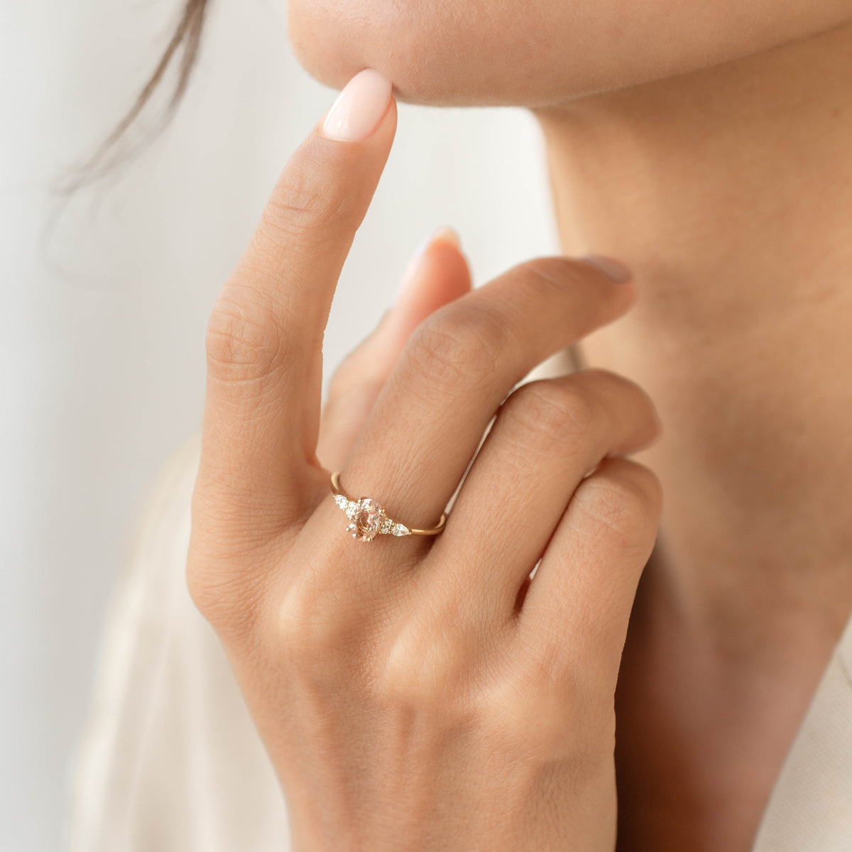 Close-up of a hand wearing the Morganite and Diamond Ring 14k Gold - Rochelle with a soft neutral background