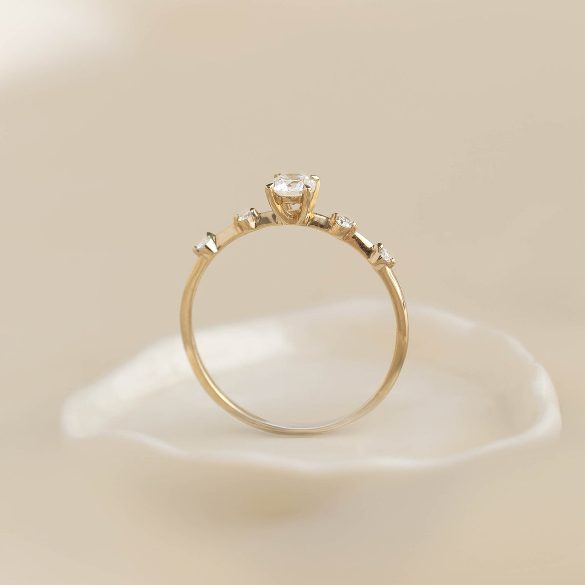 Round Diamond Ring 14k Gold - Rocio with brilliant round center stone and side diamonds on neutral background