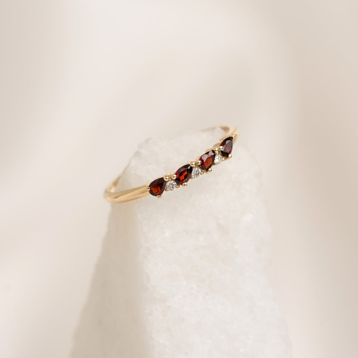 Close-up of January Birthstone Pear Ring 14k Gold - Garnet and Diamond with alternating red garnets and small diamonds on gold band