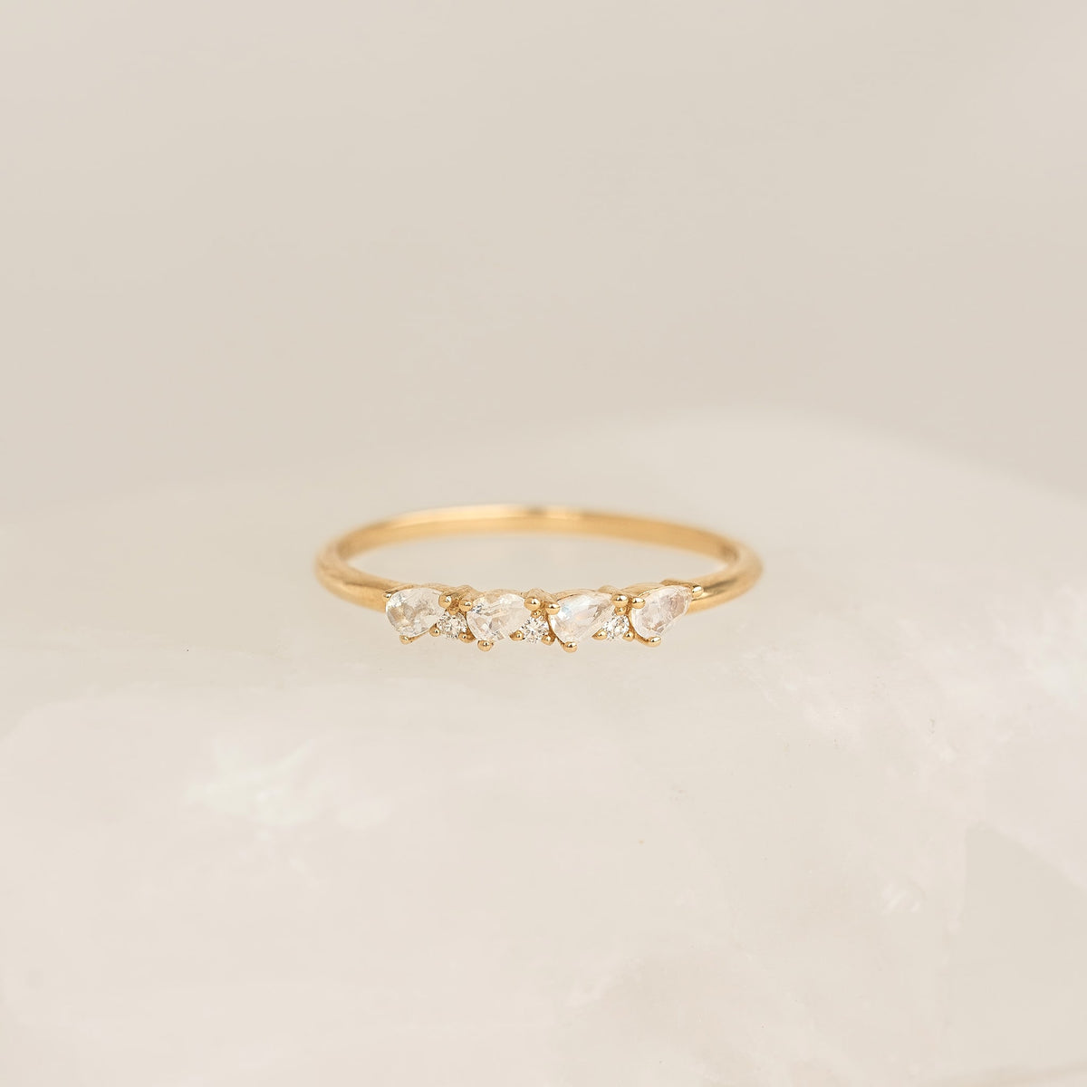 Close-up of June Birthstone Pear Ring 14k Gold - Moonstone and Diamond on soft beige surface with neutral background