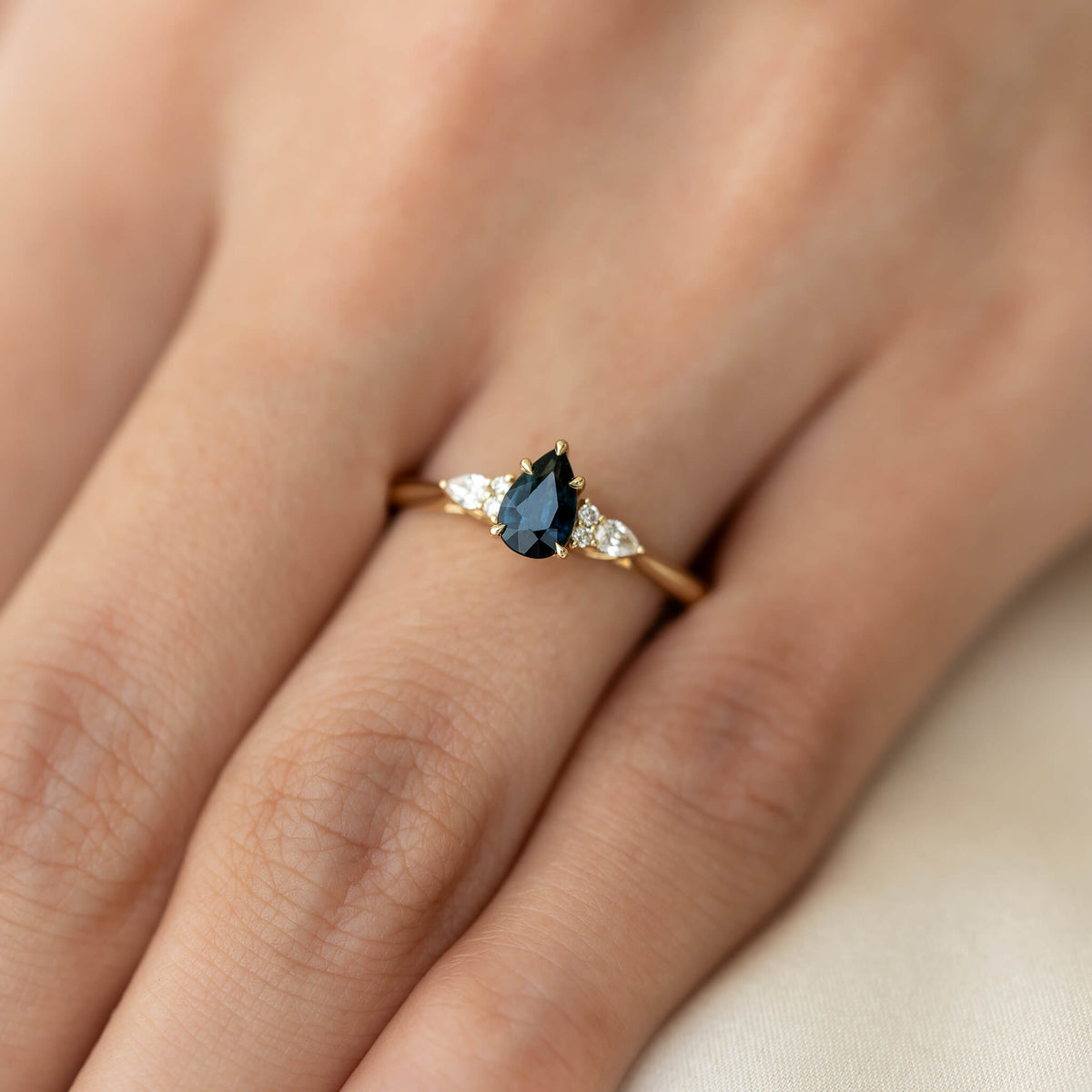 A close-up photograph shows the same yellow Gold ring being worn on a person's ring finger, providing a sense of scale.