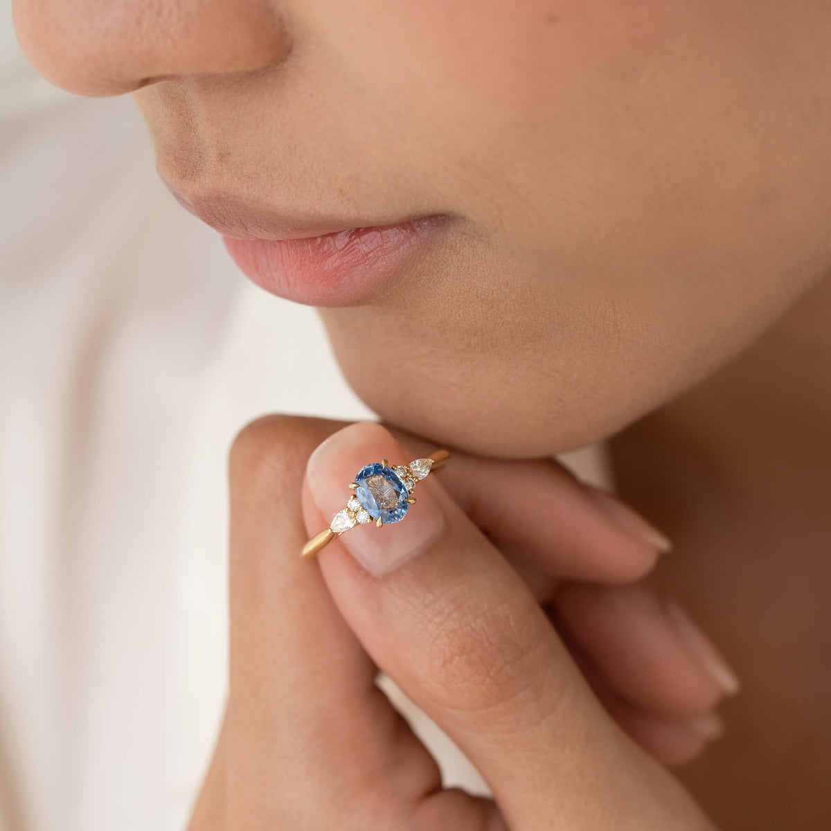 The set features an ring with a round, bright blue sapphire center stone flanked by tiny cluster diamonds.
