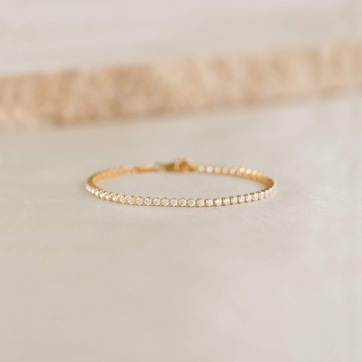 Close-up of the Tennis Bracelet - Audrey featuring sparkling cubic zirconia stones set in gold vermeil on a neutral surface
