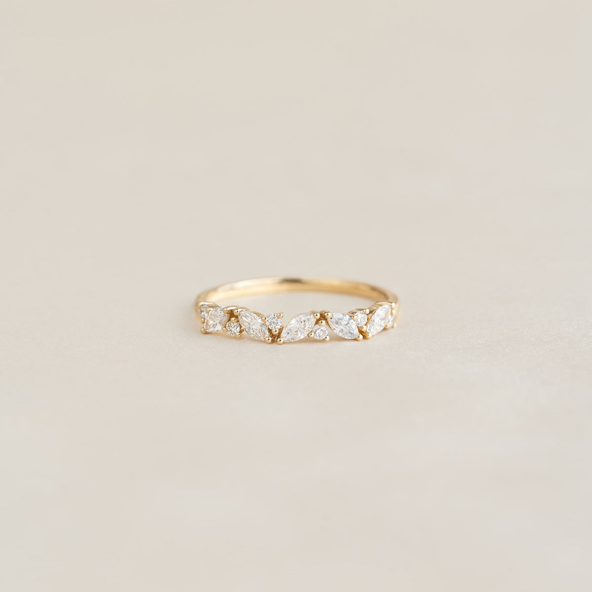 Close-up of Marquise and Round Diamond Ring 14k Gold - Celia with floral diamond details on a neutral background