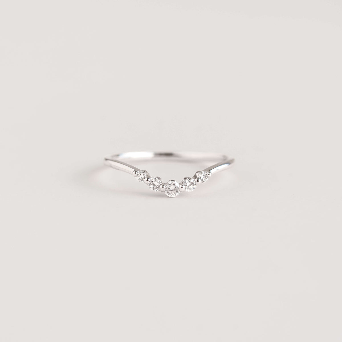 Close-up of a Graduated Diamond V Ring White Gold - Liora with five graduated diamonds on a delicate band
