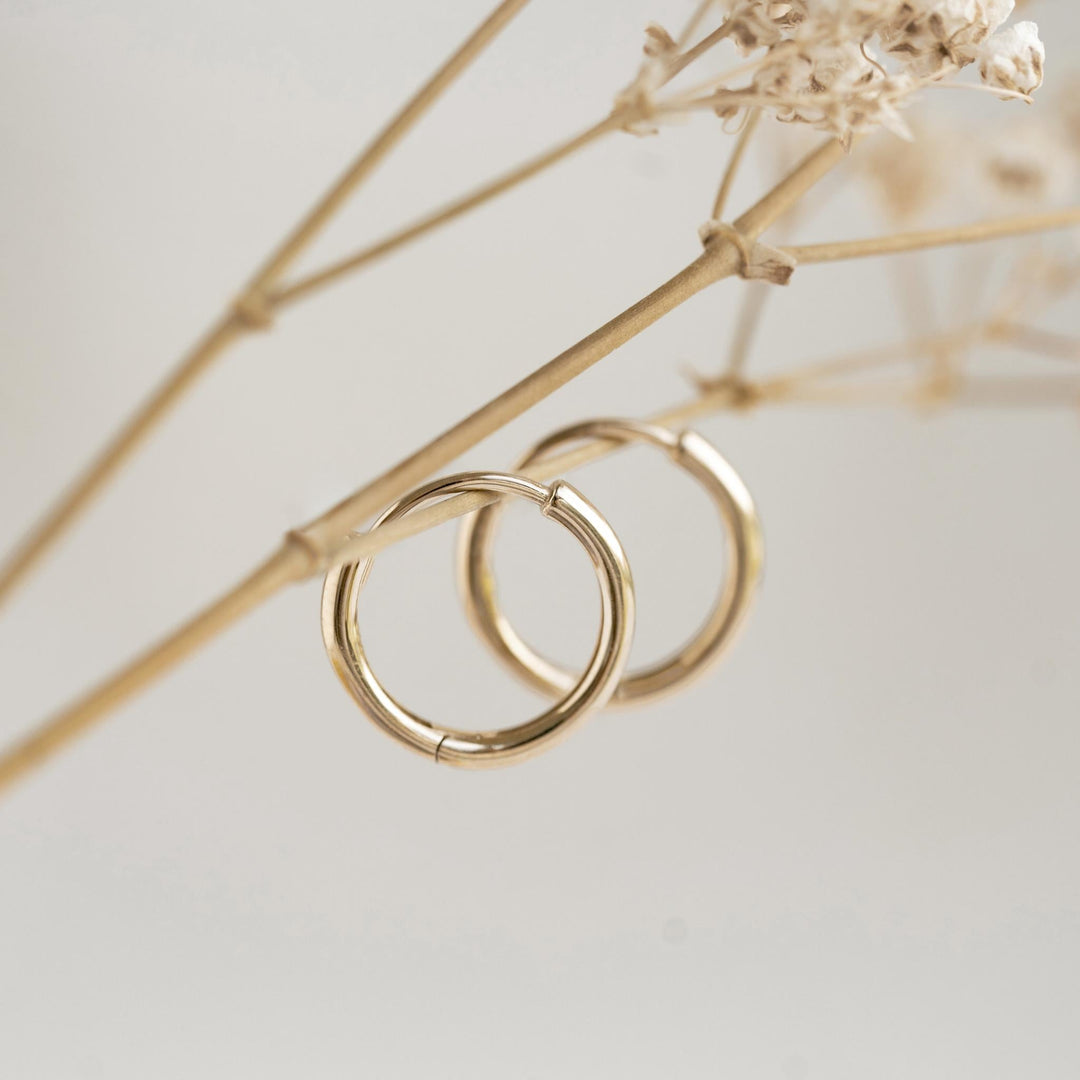 Gold huggie earrings with a hinge closure