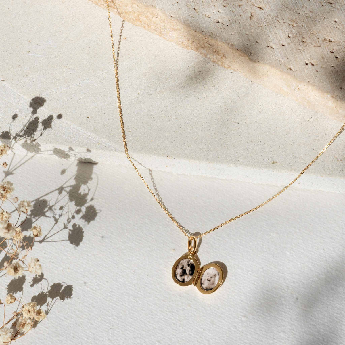 Locket Necklace Silver - Marte with a delicate open silver locket pendant on a long thin chain against a neutral background