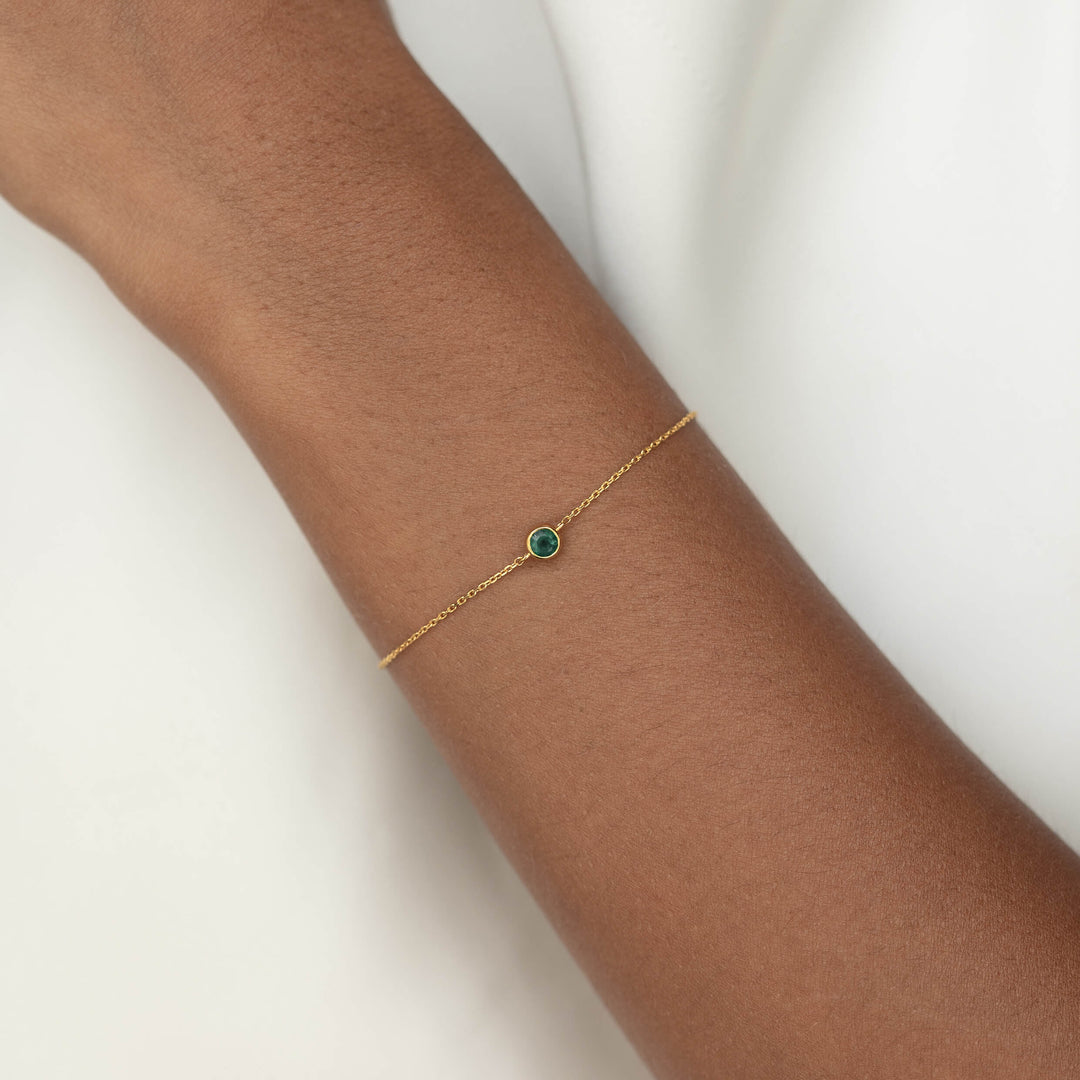 Delicate Gold Vermeil chain bracelet with a small round Green chalcedony gemstone centerpiece, worn around a woman's wrist.
