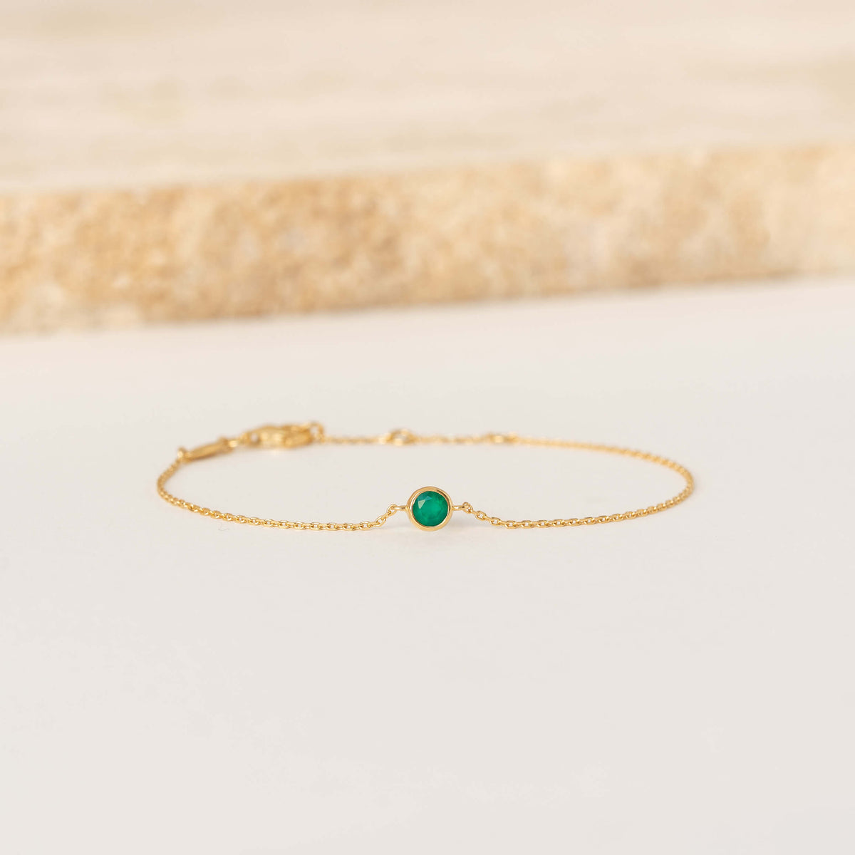 Delicate Gold Vermeil chain bracelet featuring a small round Green chalcedony gemstone centerpiece, laid flat on a light-colored surface.