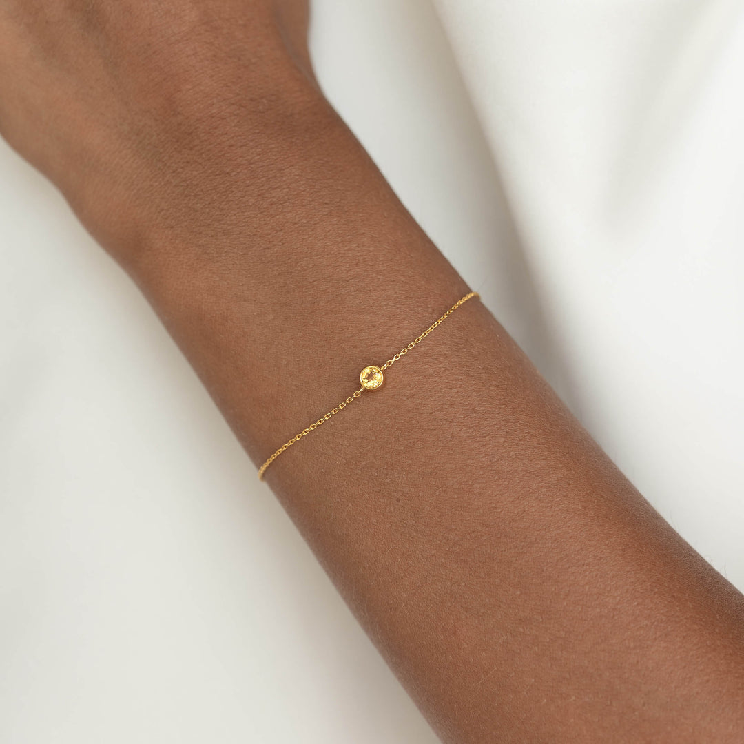 Delicate Gold Vermeil chain bracelet with a small round Citrine gemstone centerpiece, worn around a woman's wrist.