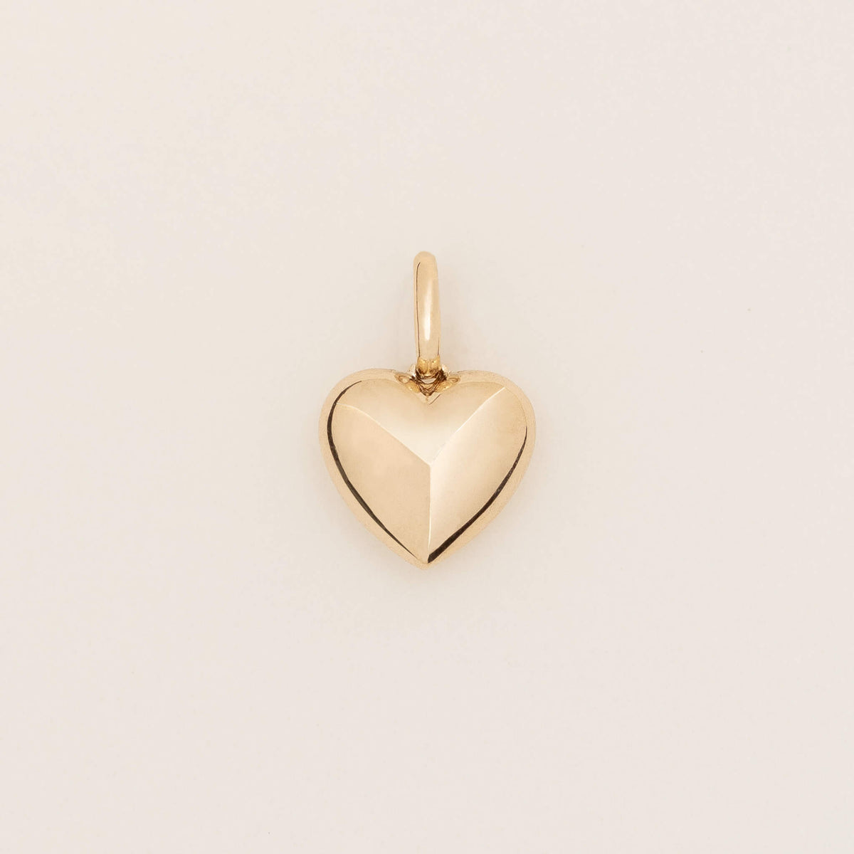 Yellow Gold heart-shaped pendant with a faceted geometric design and polished finish, shown against a light neutral background.