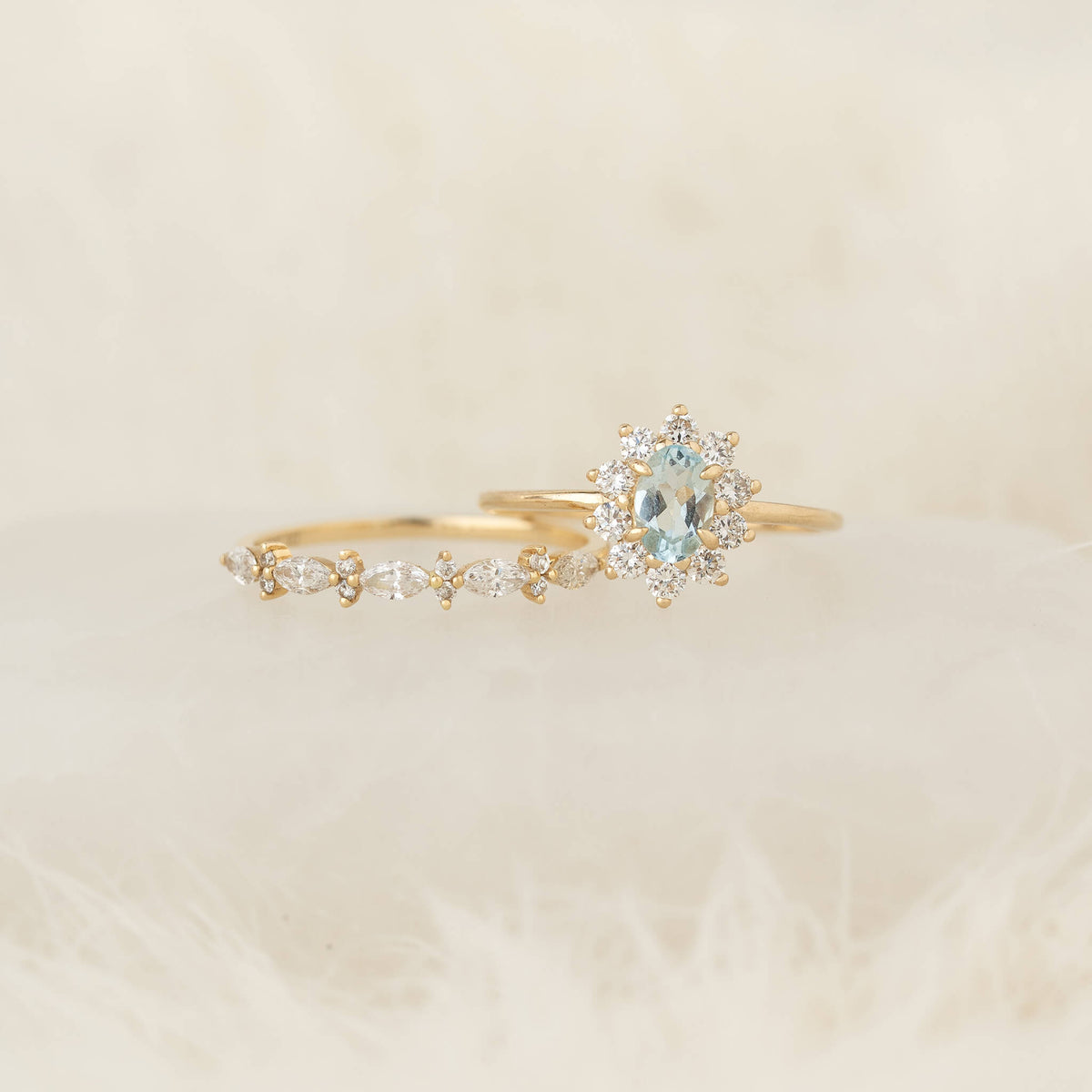 Gold ring set features a marquise-cut gemstone and diamond accents, elegantly displayed on soft, white fur, evoking a sense of luxury and romance.