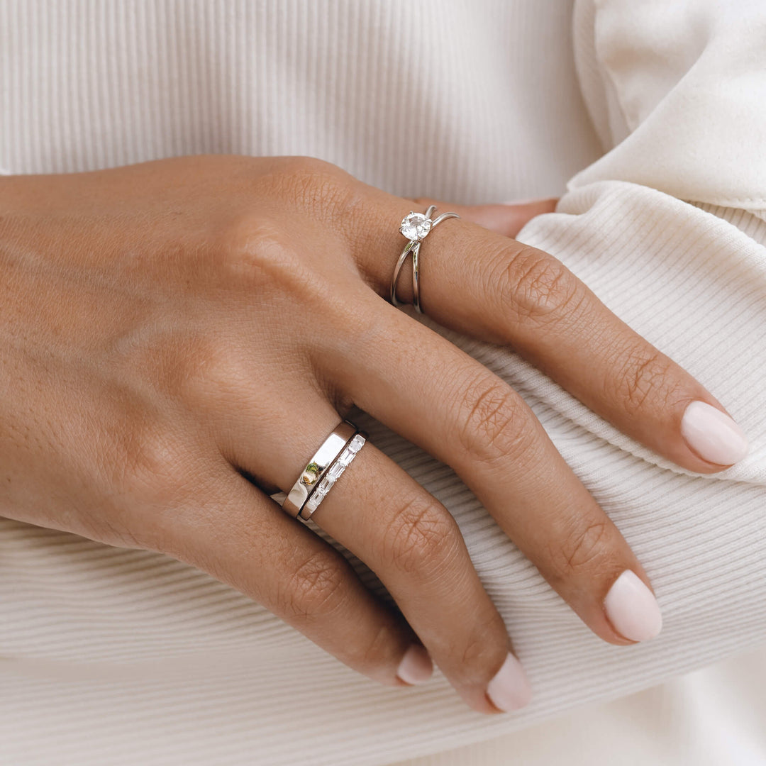 Wide band silver ring stacked on model